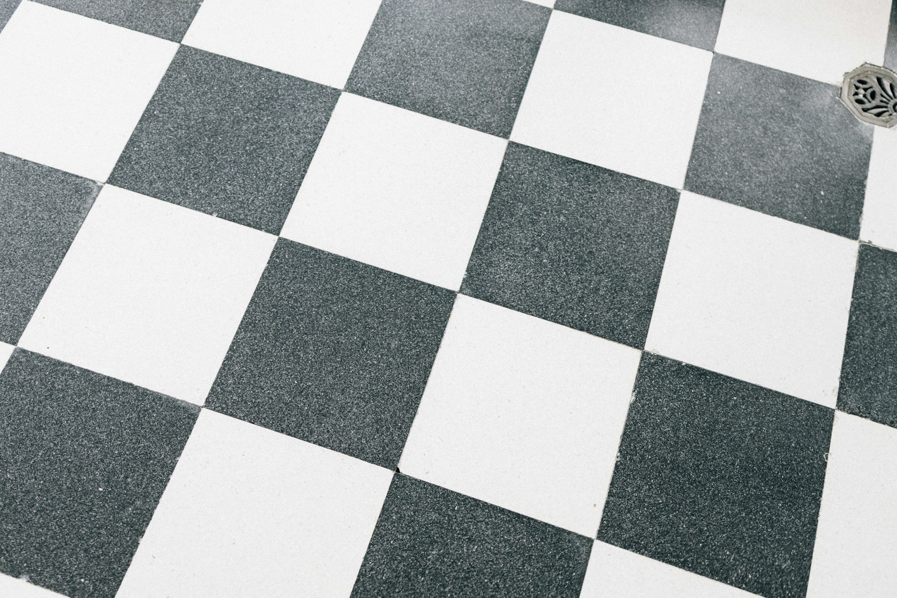 Stone-visual tile laid as a checkerboard across a commercial floor