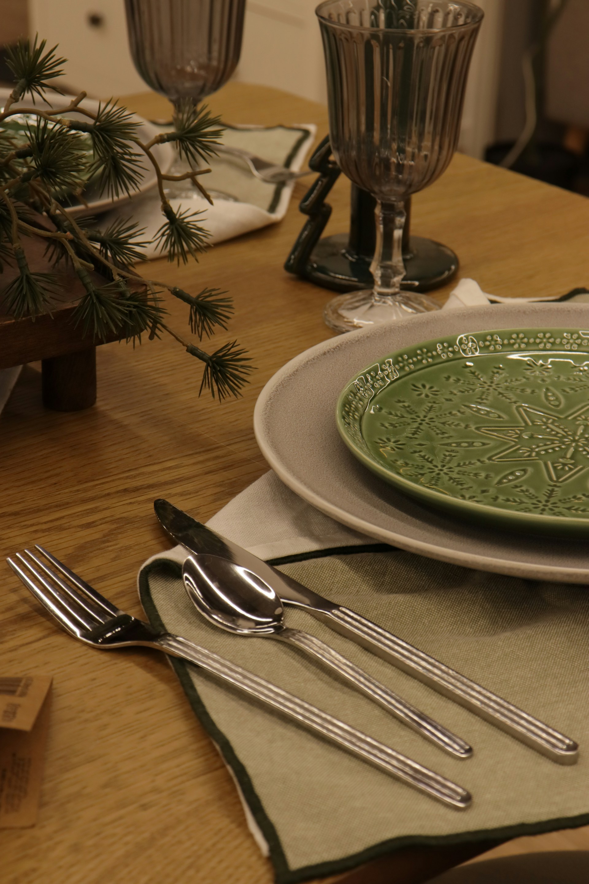 Table setting with silverware, plates, and glasses.