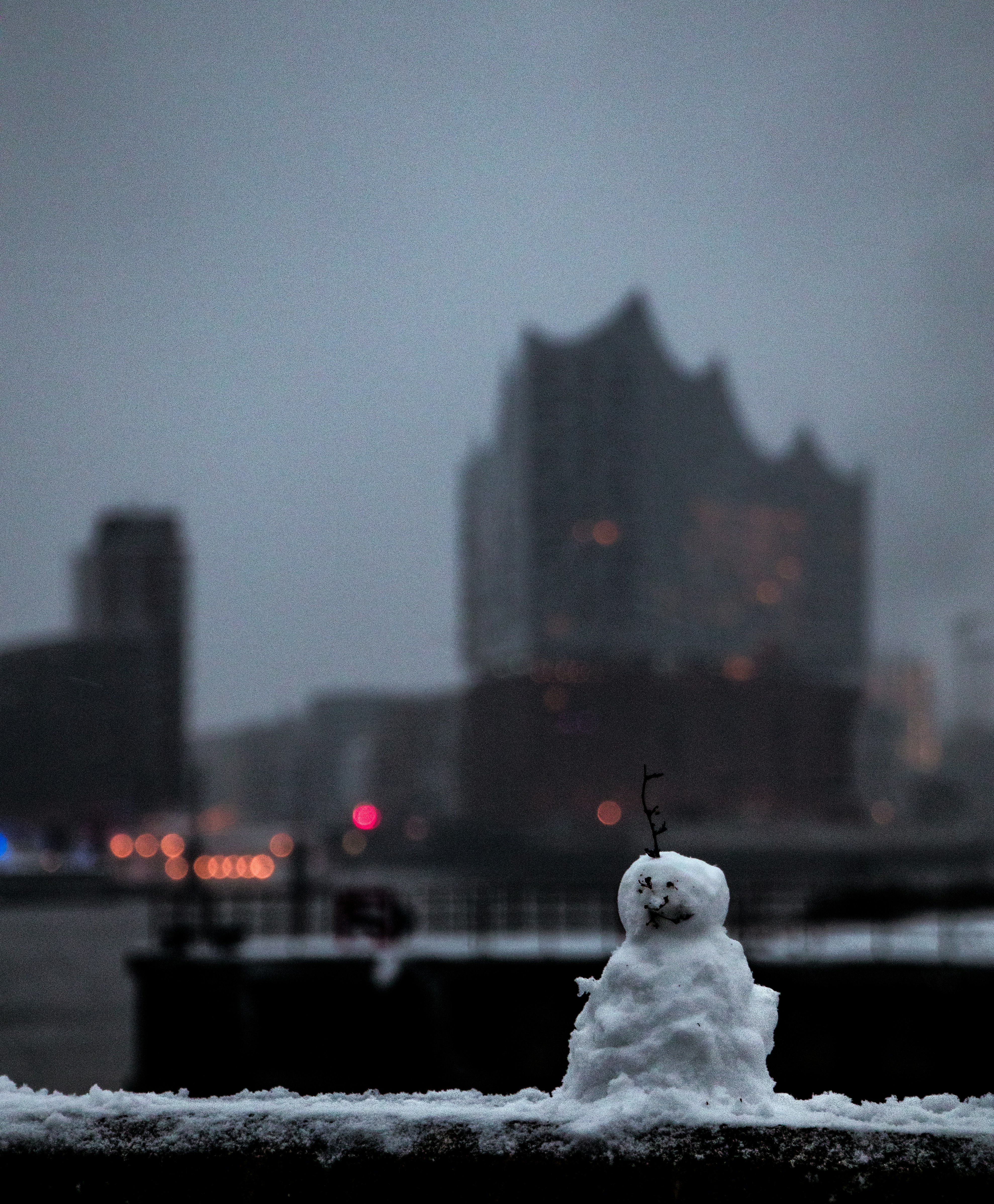 Small snowman with city skyline in background