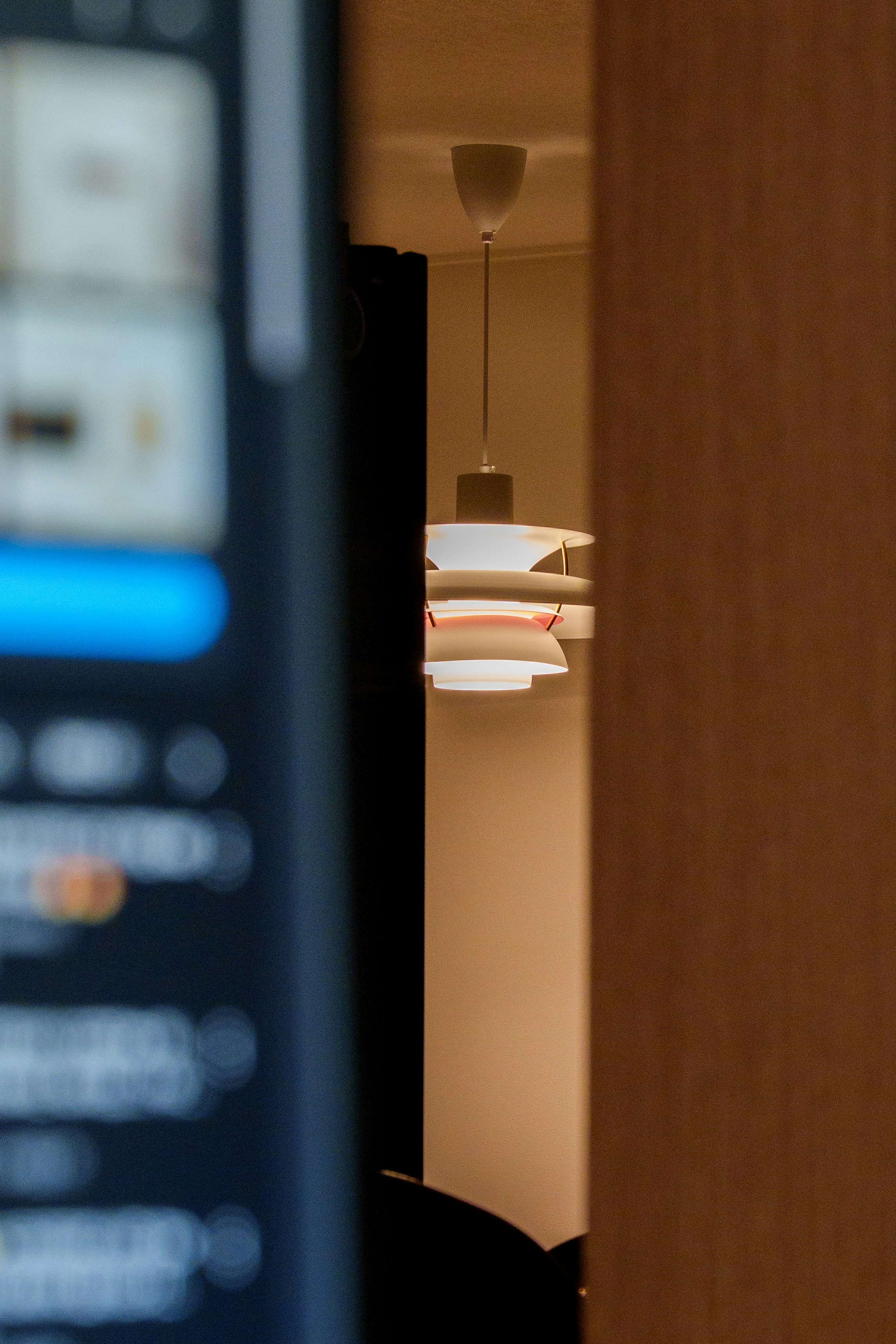 Modern pendant light fixture hangs in a room.