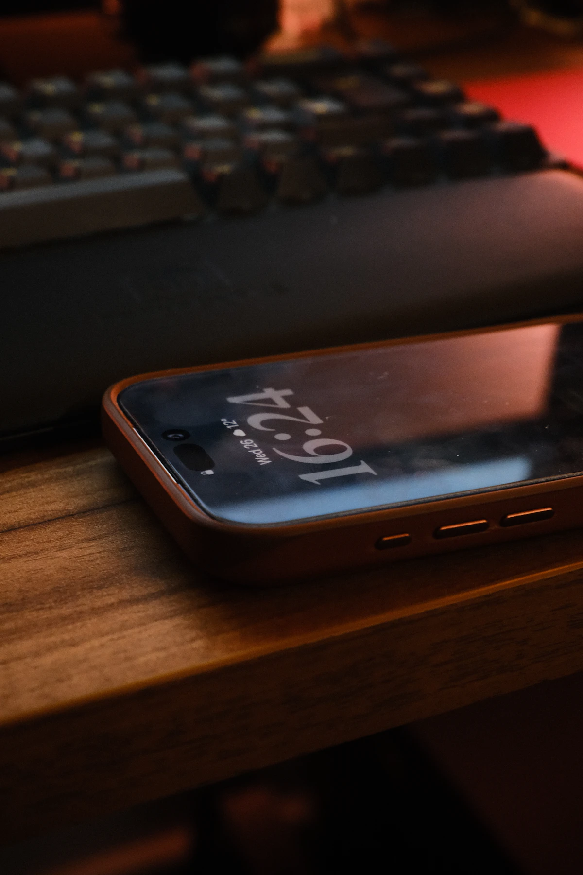 A phone face up on a desk showing the time, set aside during focused work