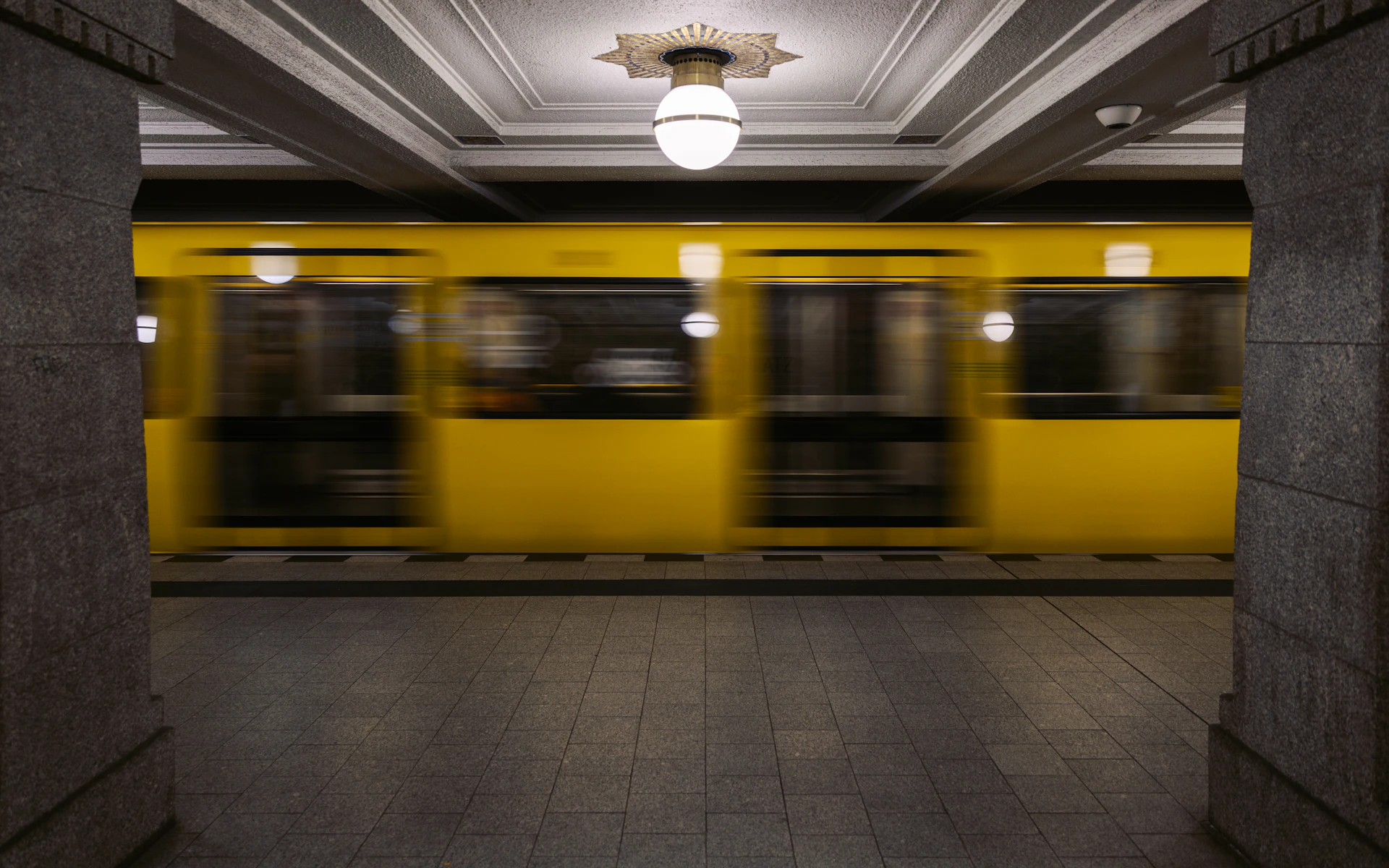 A yellow subway train blurred in motion underground.