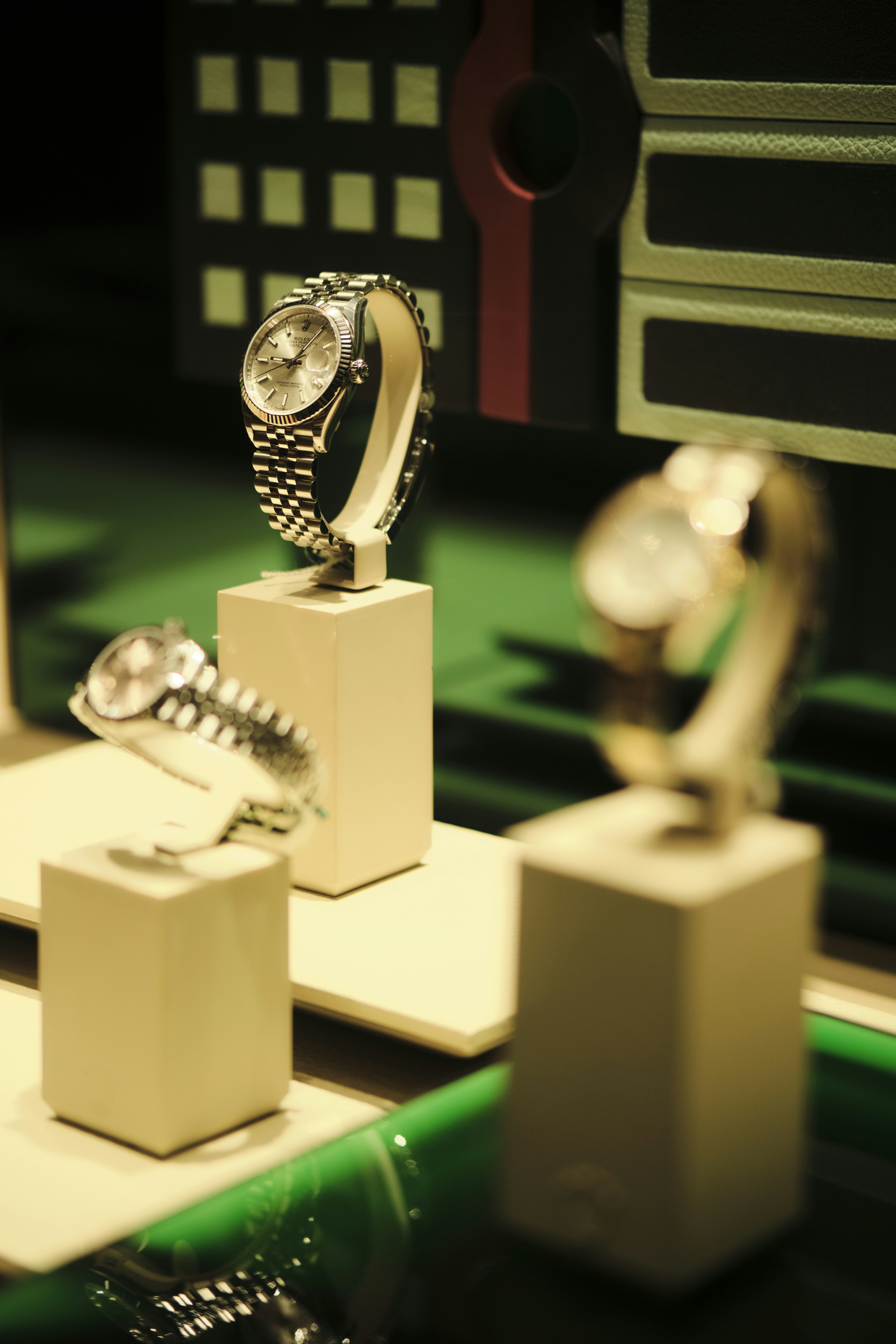 Three luxury watches displayed on stands