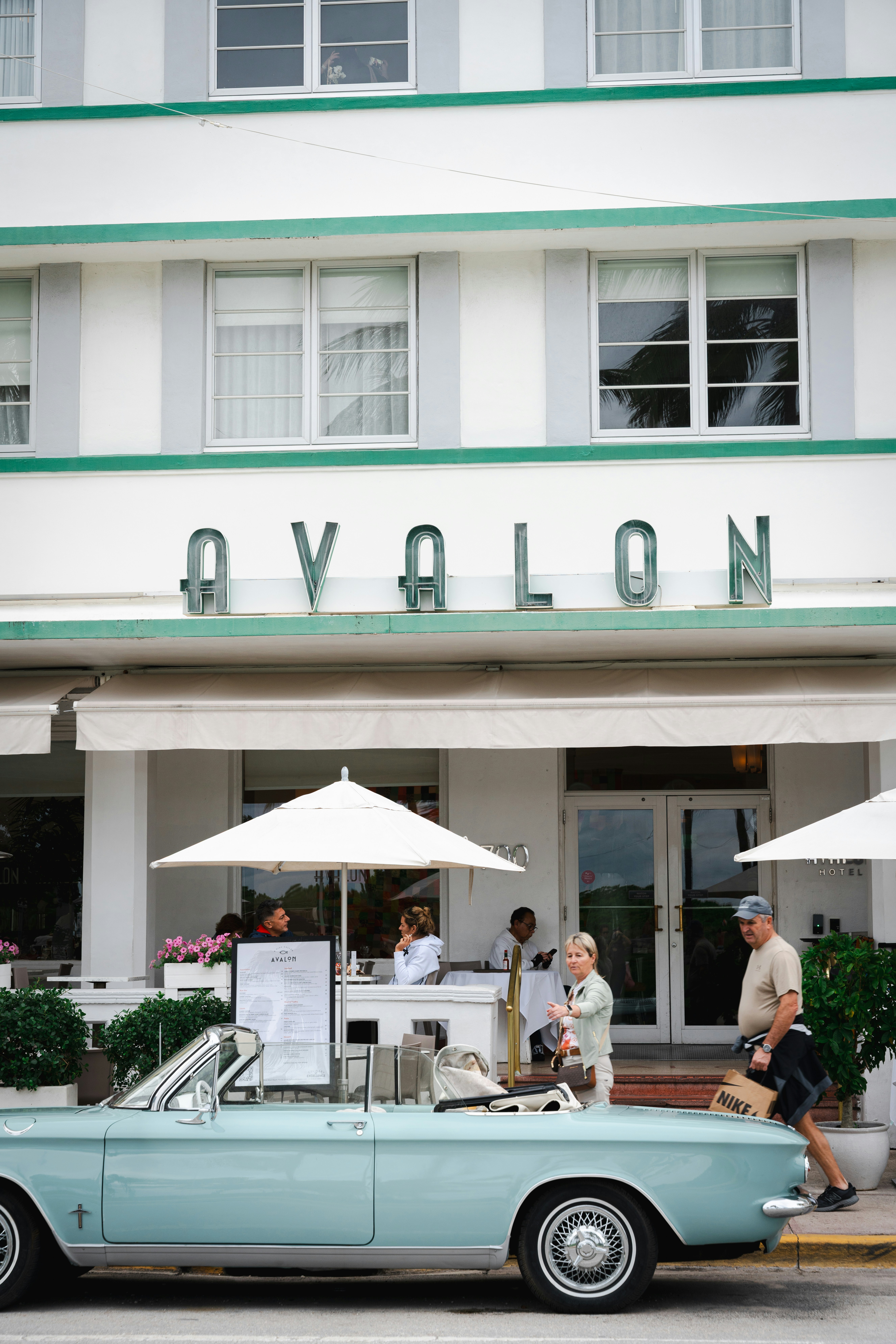 Vintage car parked outside avalon hotel with outdoor seating