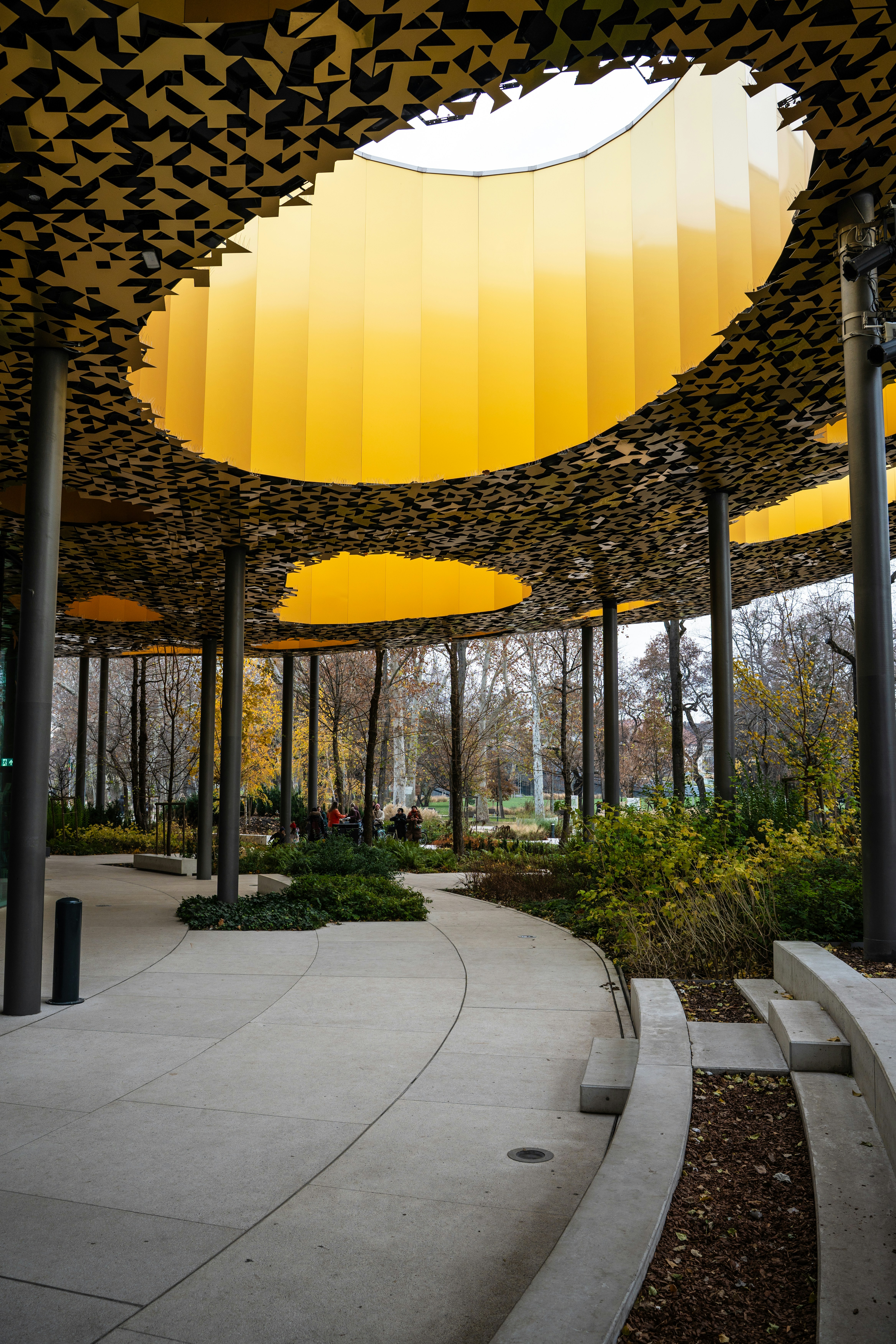 Modern outdoor pavilion with yellow ceiling and trees
