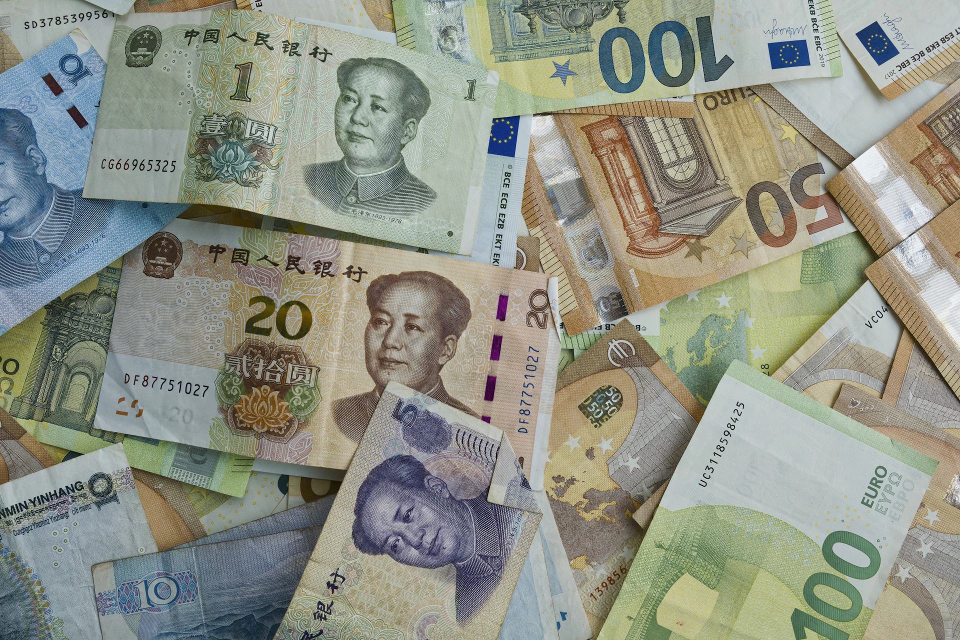 Chinese yuan and european euro banknotes scattered together.