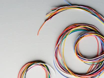 Colorful wires coiled on a gray surface
