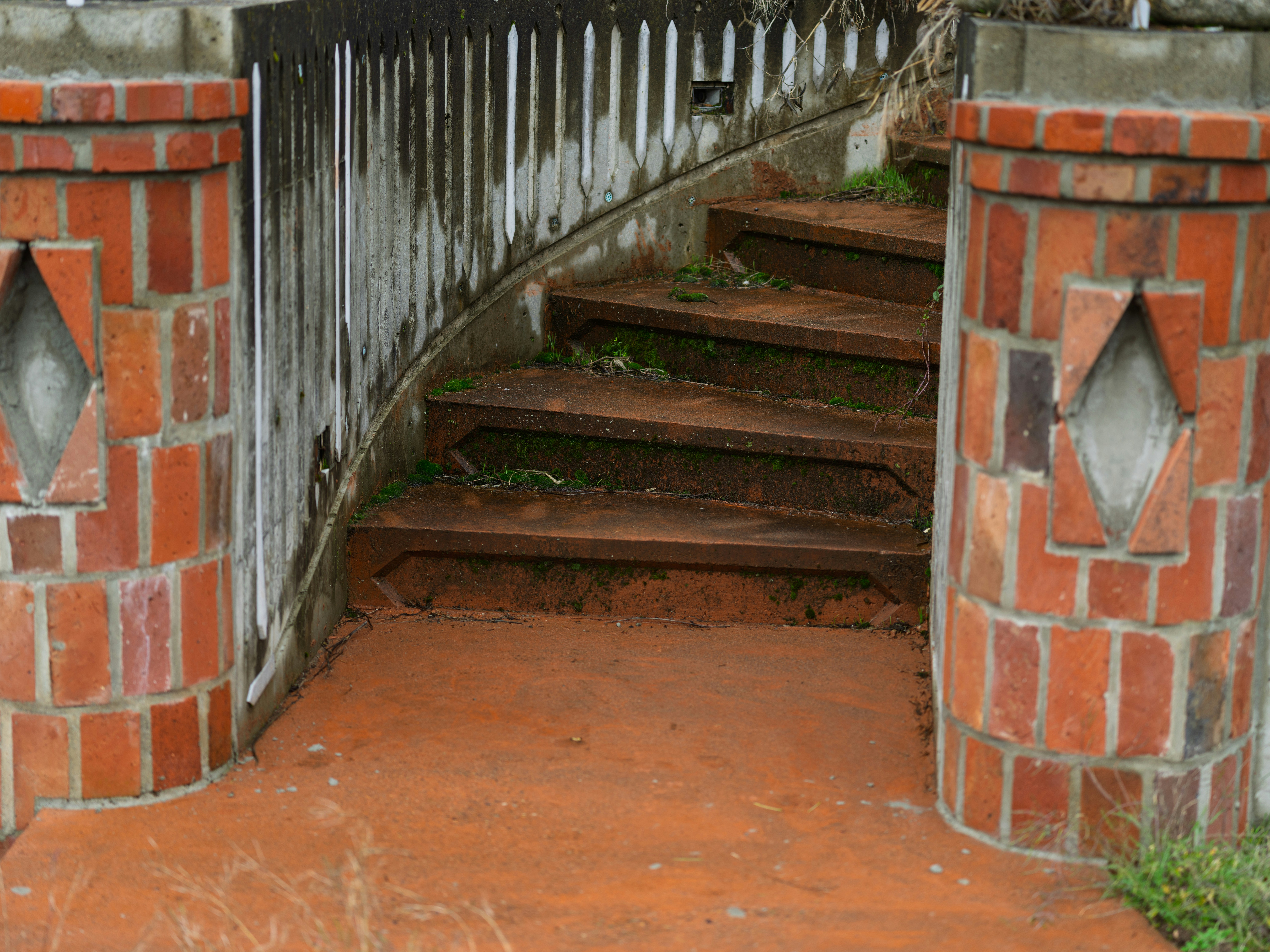 Outdoor brick pillars frame rusty metal stairs