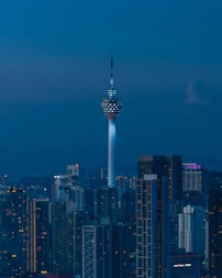 Skyscraper illuminated against a dark blue night sky.