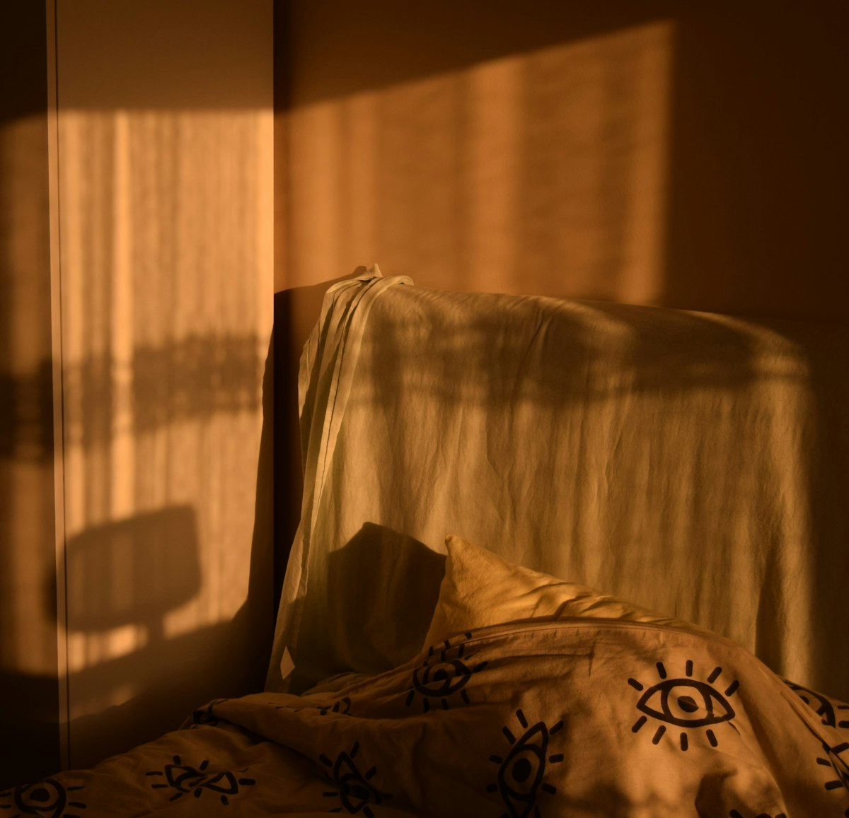 Warm afternoon light streaming into a corner bedroom, ambient and still
