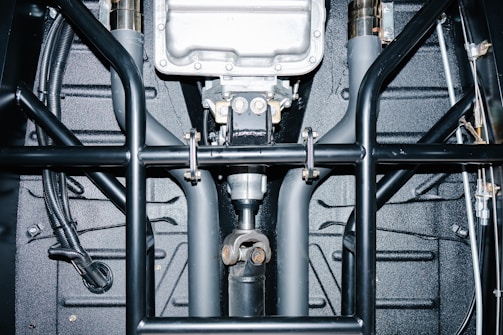 Underside view of a car's drivetrain and roll cage