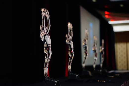 Several clear statuettes stand in a row.