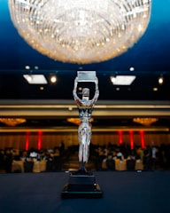 A silver award trophy stands on a table.