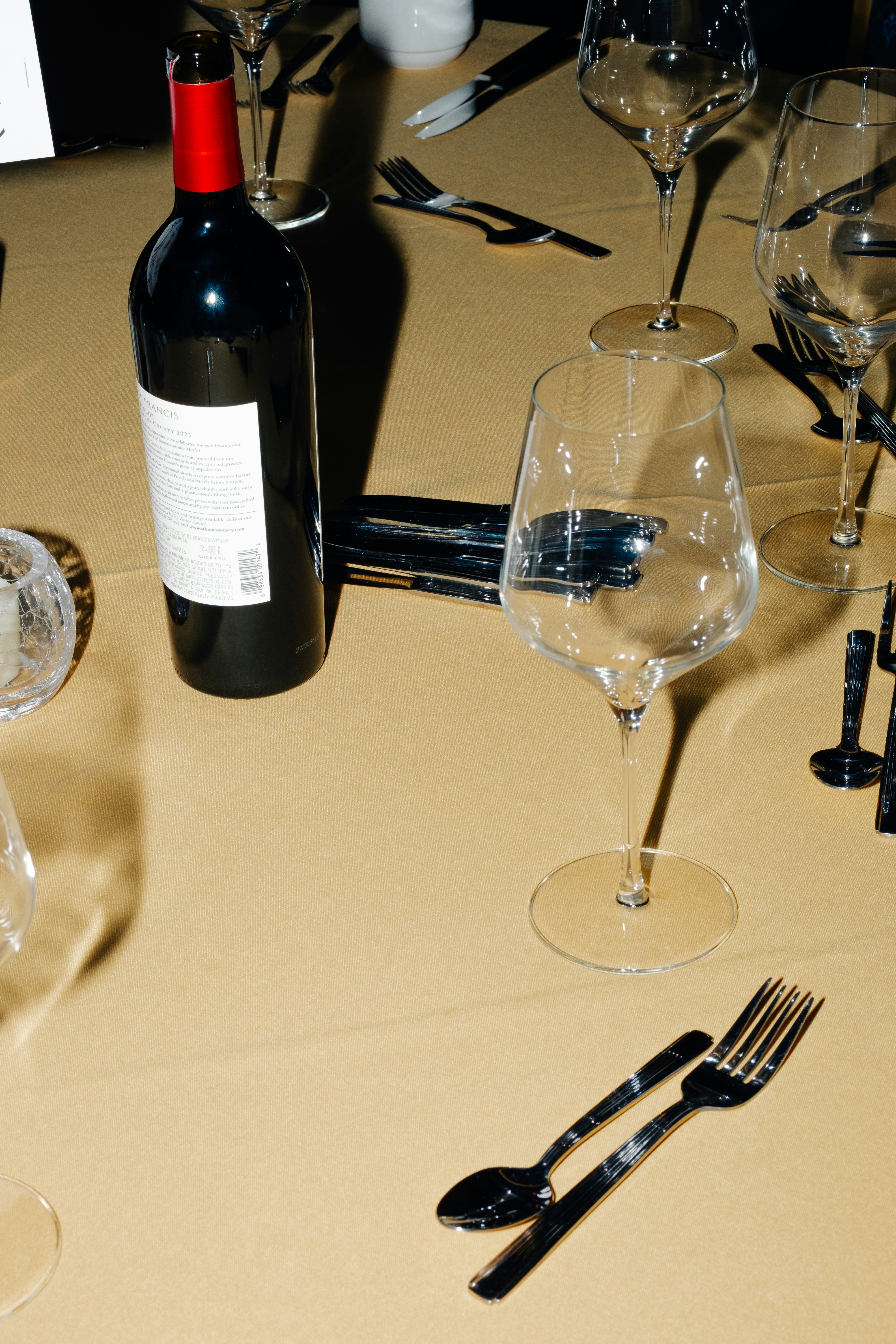 Bottle of red wine on a table with place settings