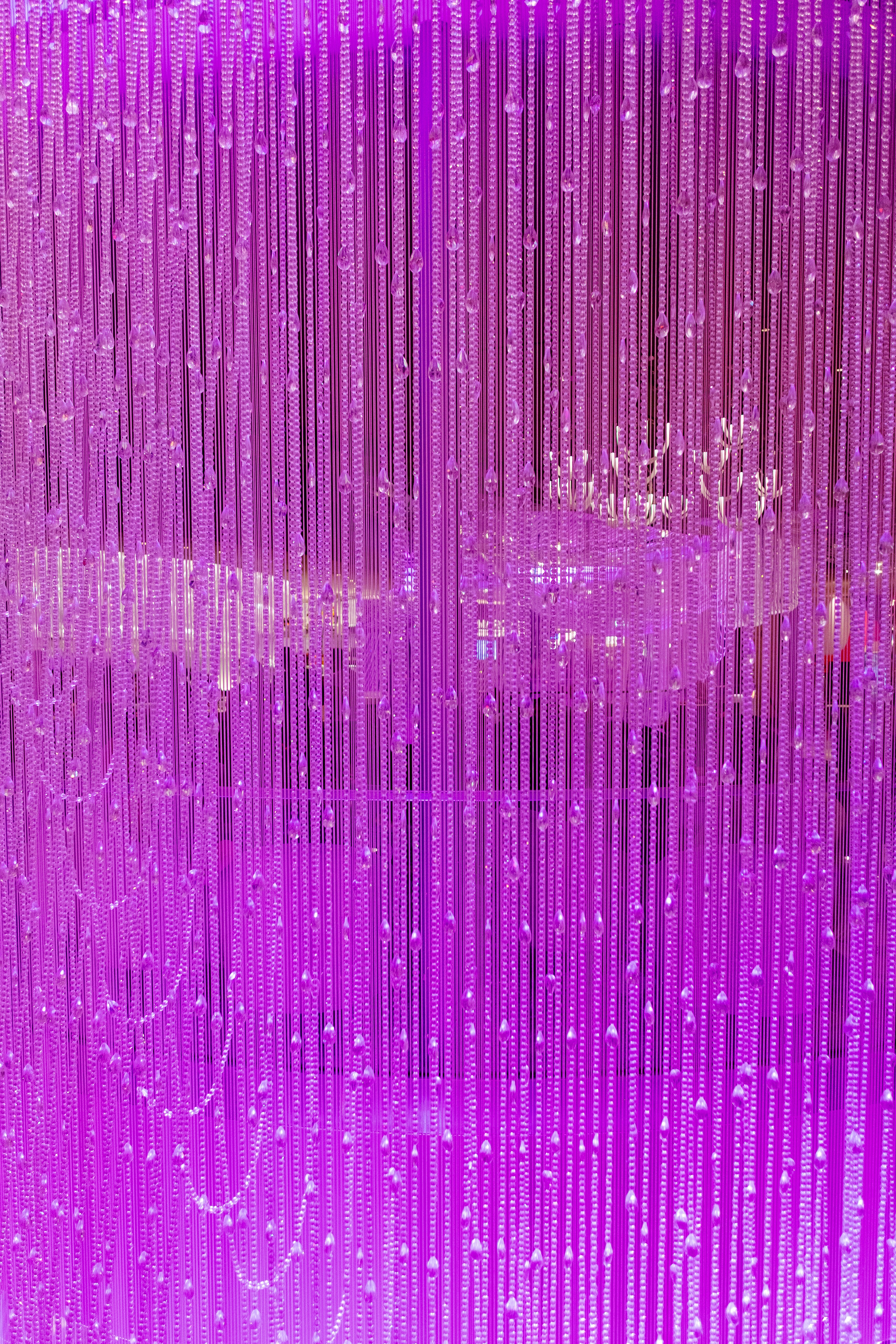 柔らかな光に包まれた紫色のビーズカーテン