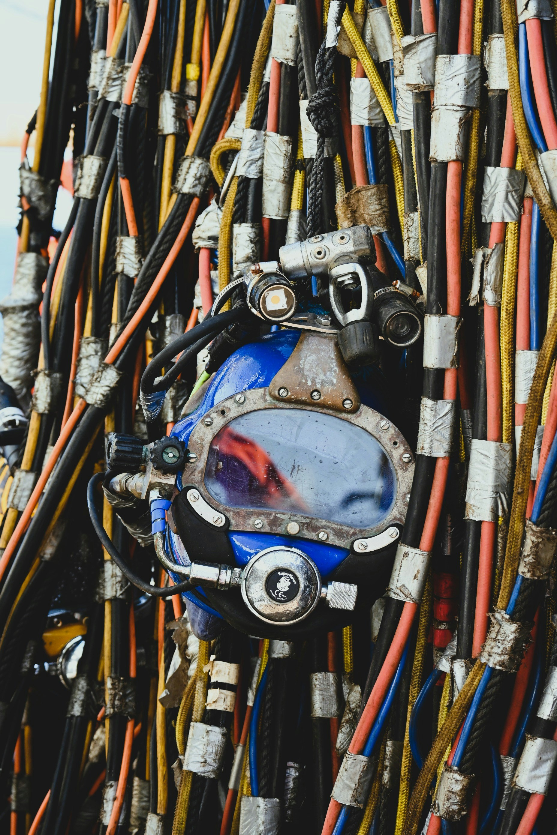 Vintage diving helmet amidst tangled cables