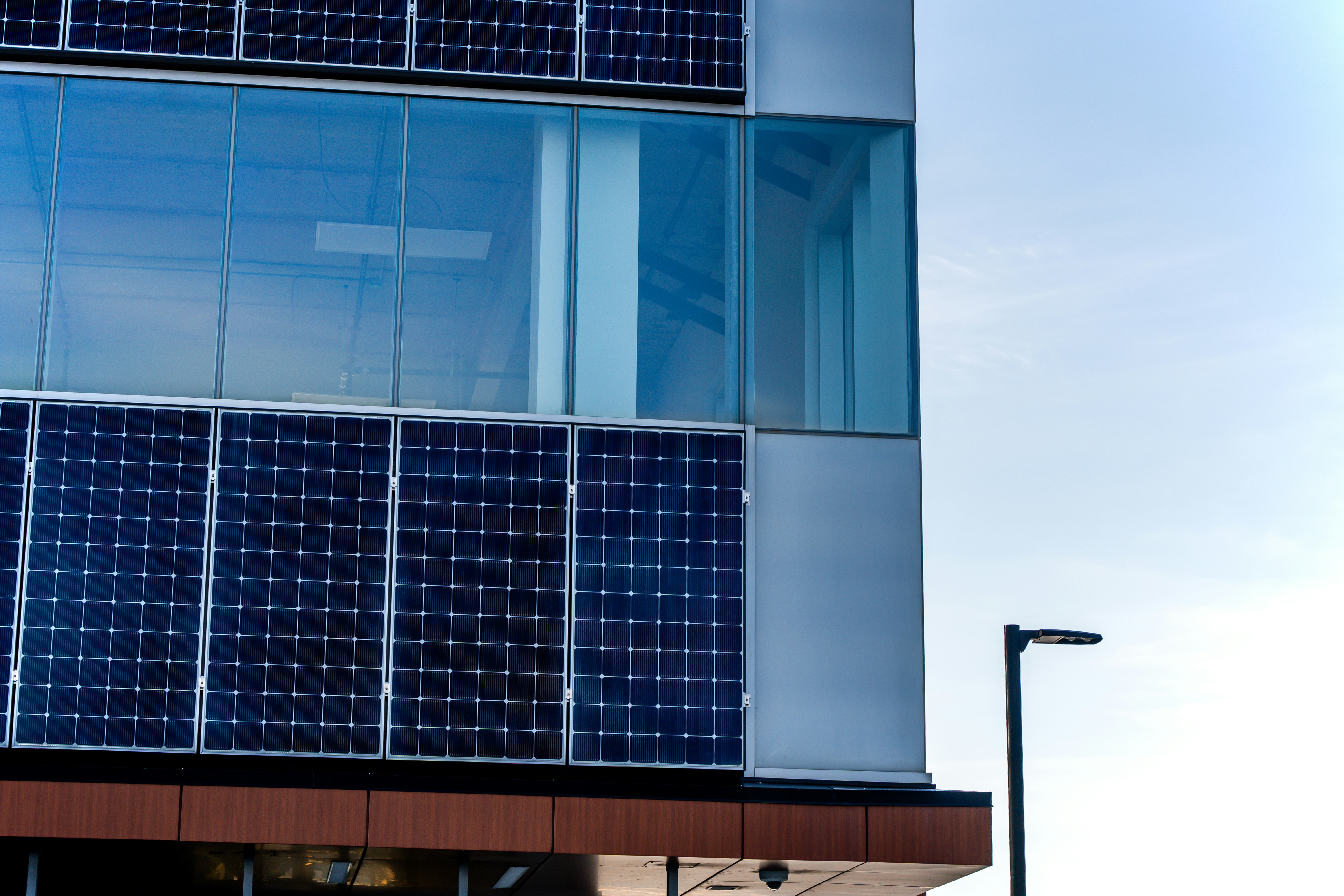 solar panels integrated into the glass facade of a modern high-rise - high-rise apartments 2028