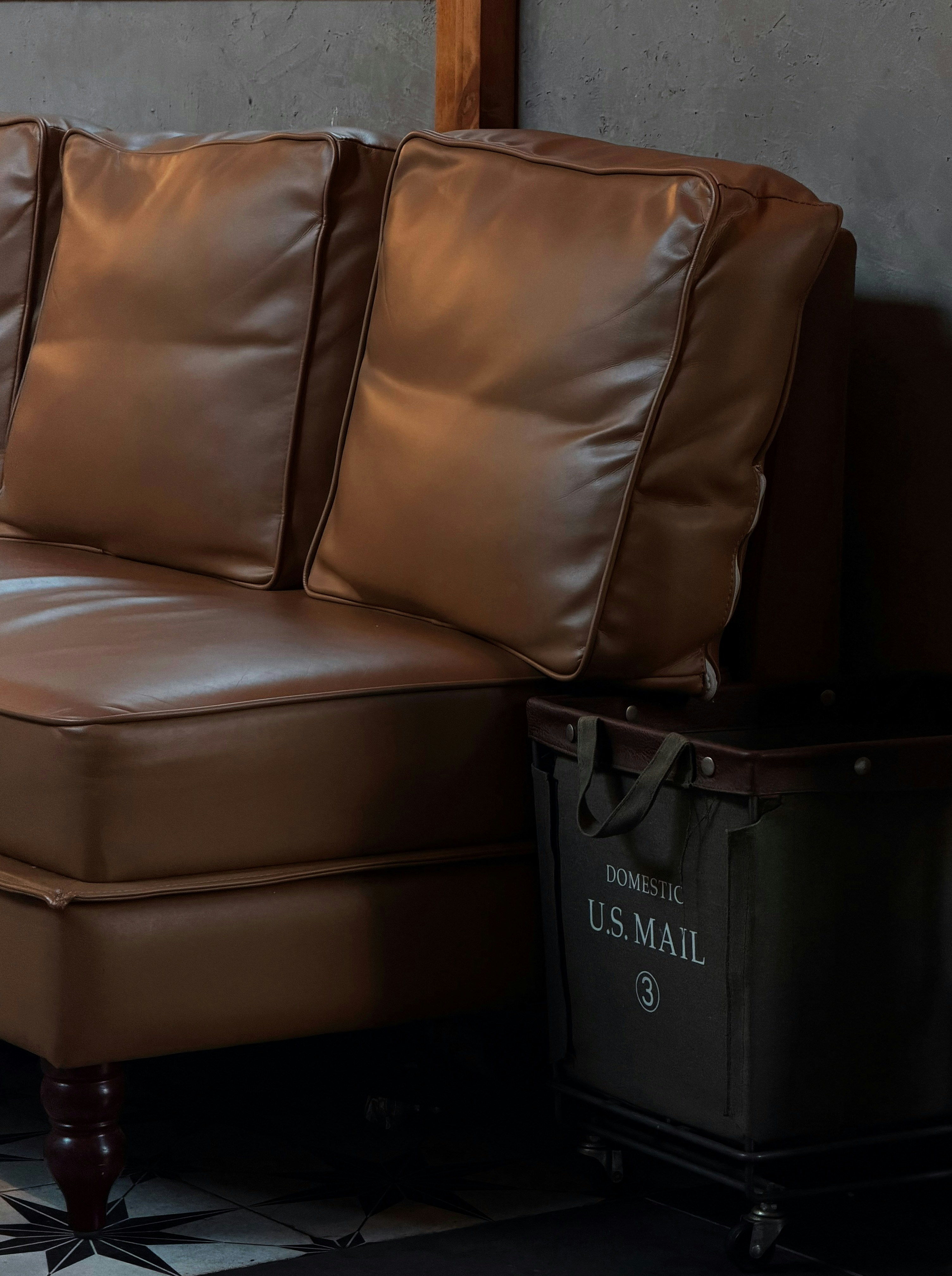Divano in pelle marrone con contenitore postale statunitense.