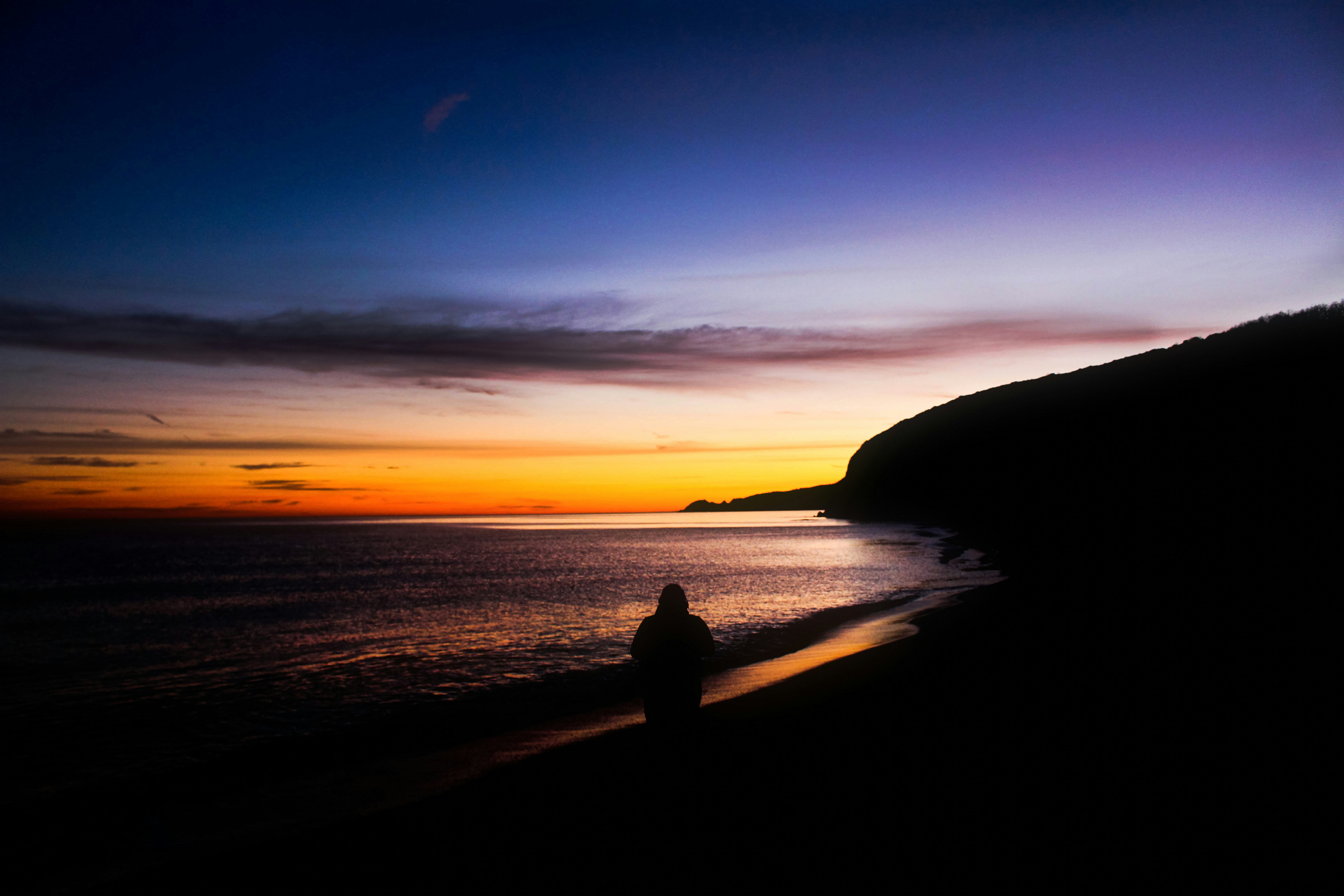 Silhouette of person on beach at sunrise