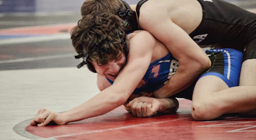 Wrestlers grappling on a mat