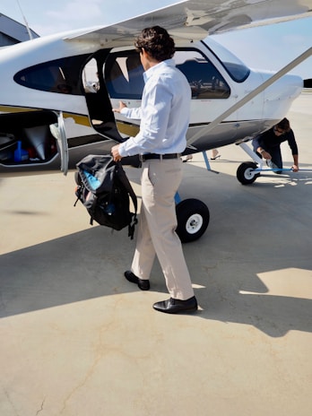 Man with backpack approaches small airplane