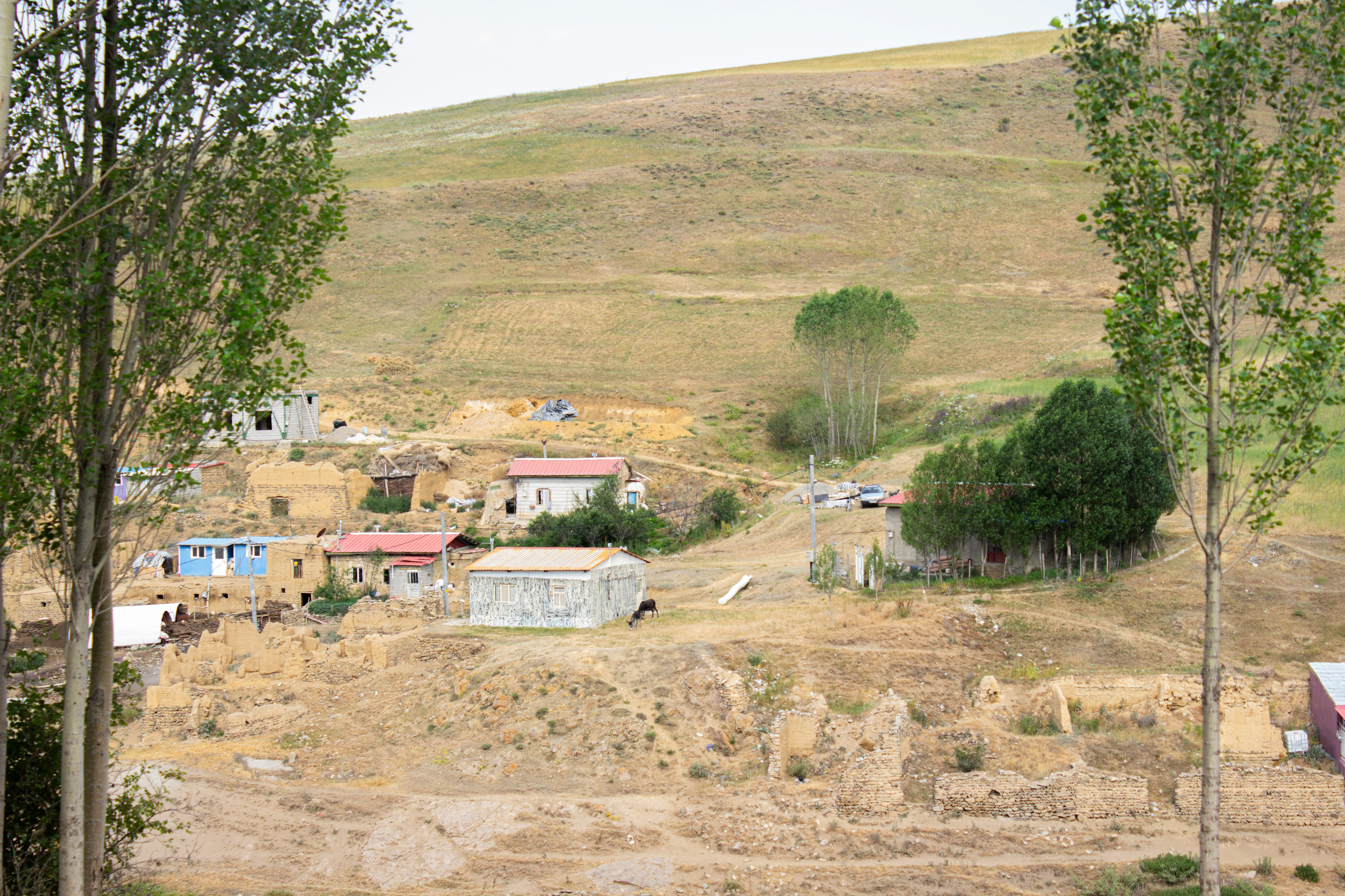 Small village nestled on a dry, grassy hillside.