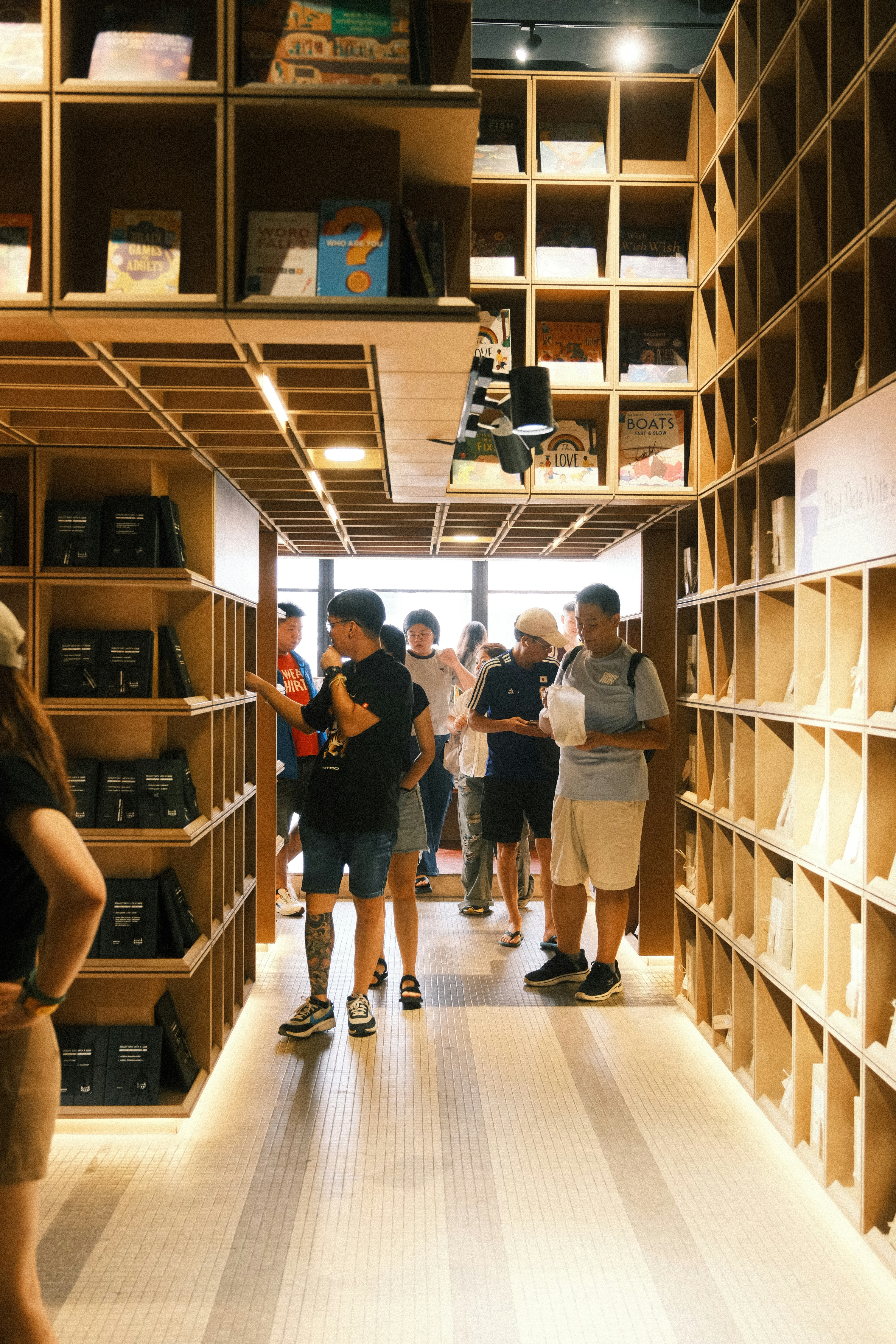 Des gens qui parcourent les étagères dans l’intérieur d’une librairie moderne.