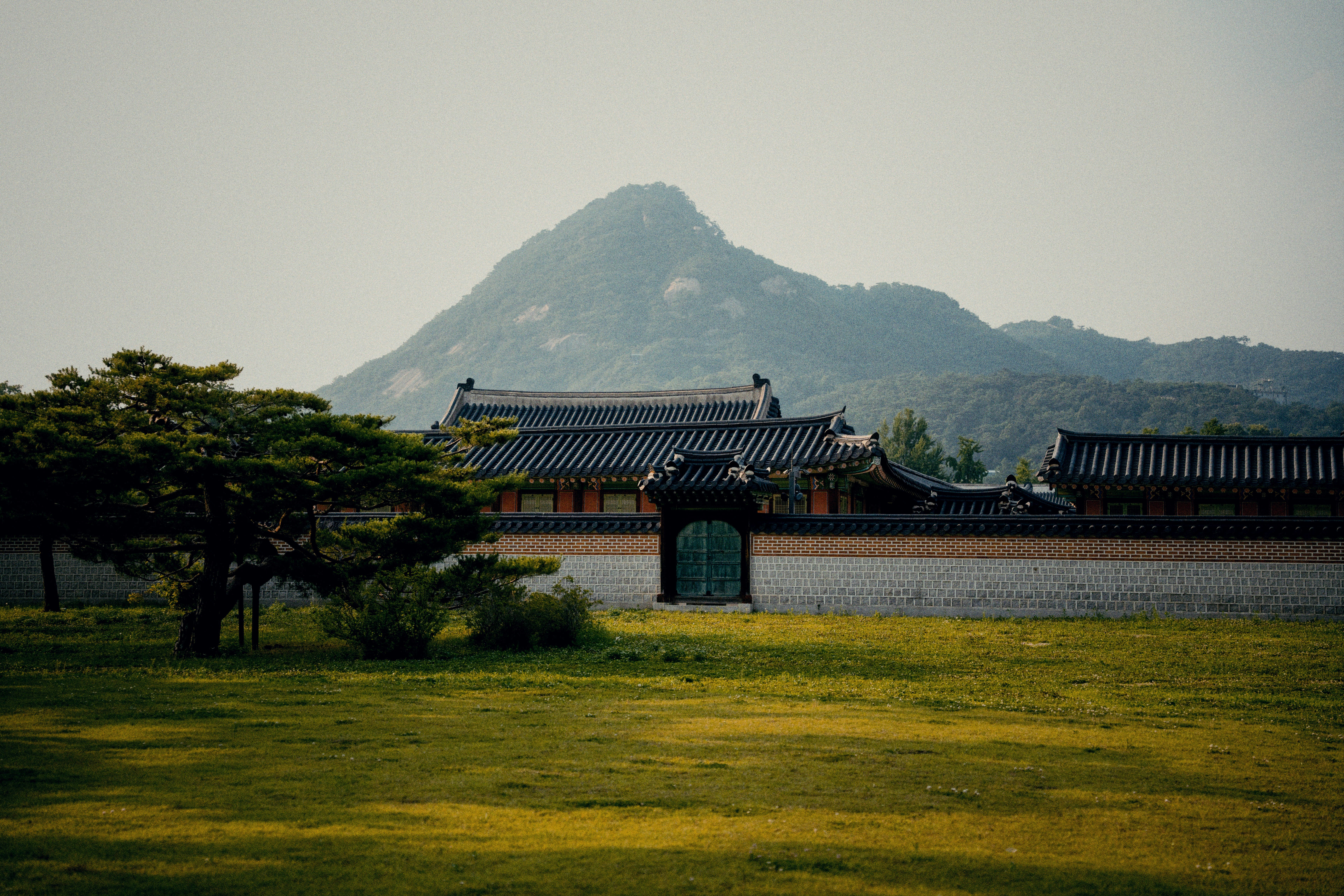 Traditional korean buildings with a mountain backdrop.