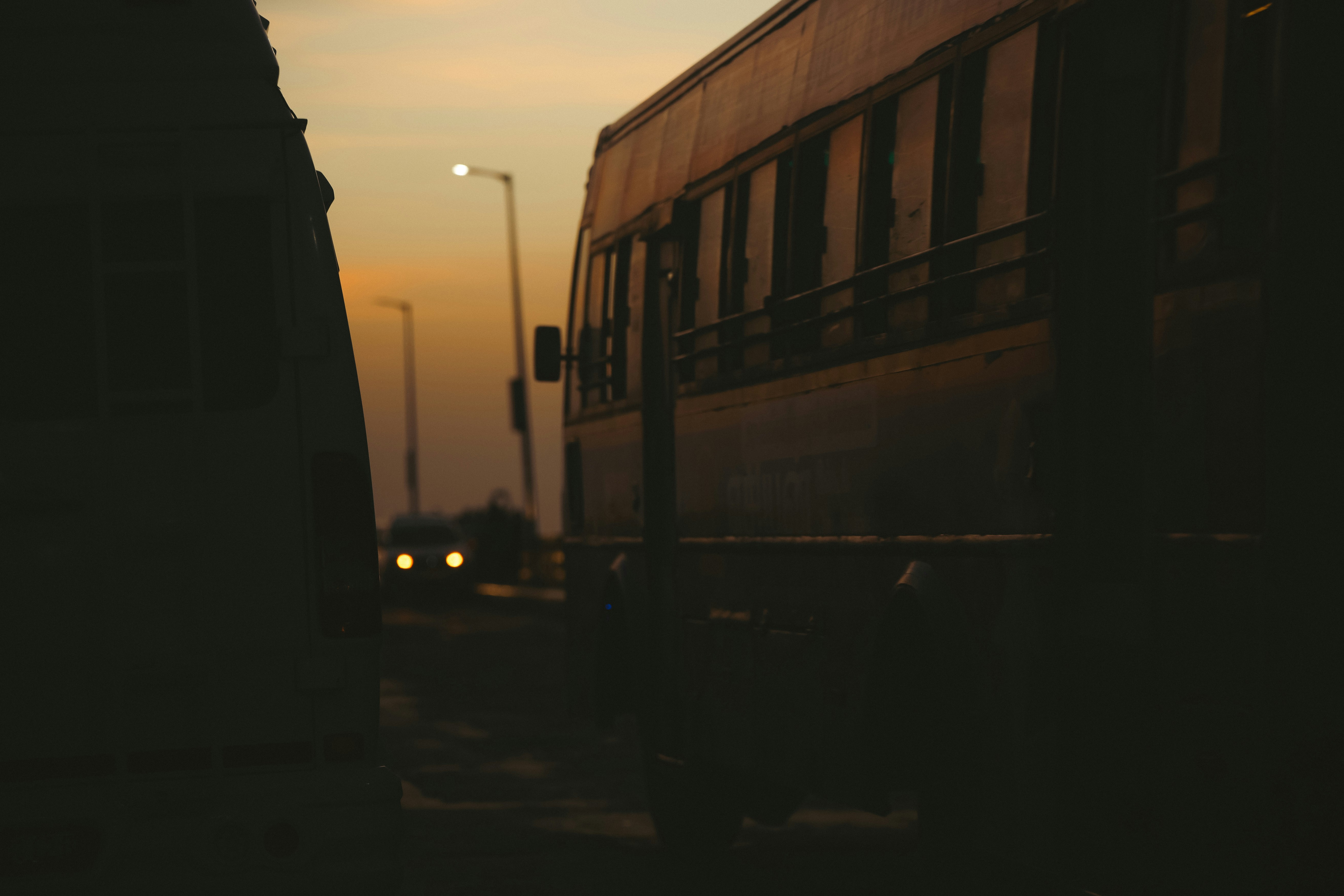 Bus traveling on road during sunset