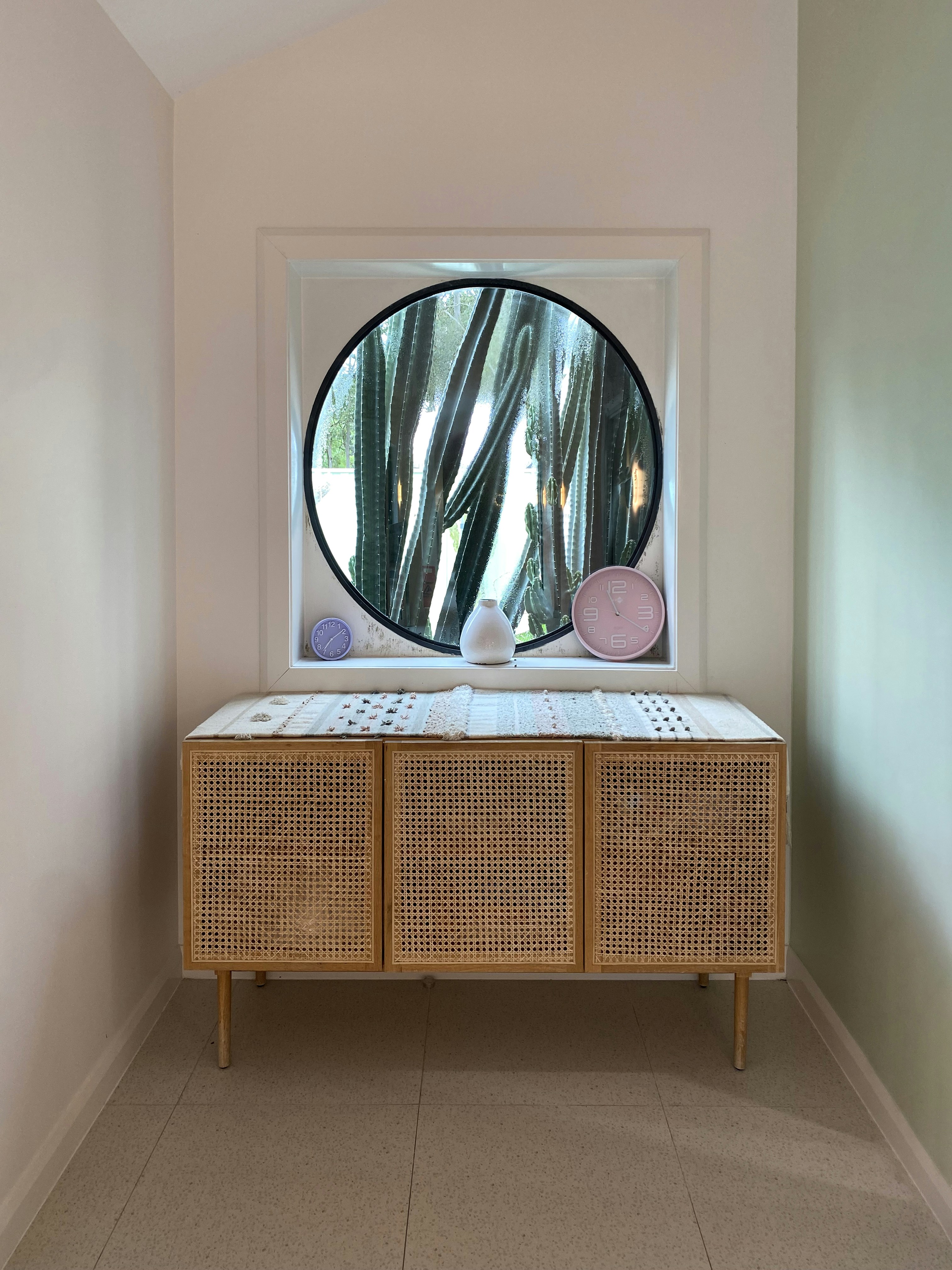 Weidenschrank mit dekorativen Elementen und rundem Fenster.