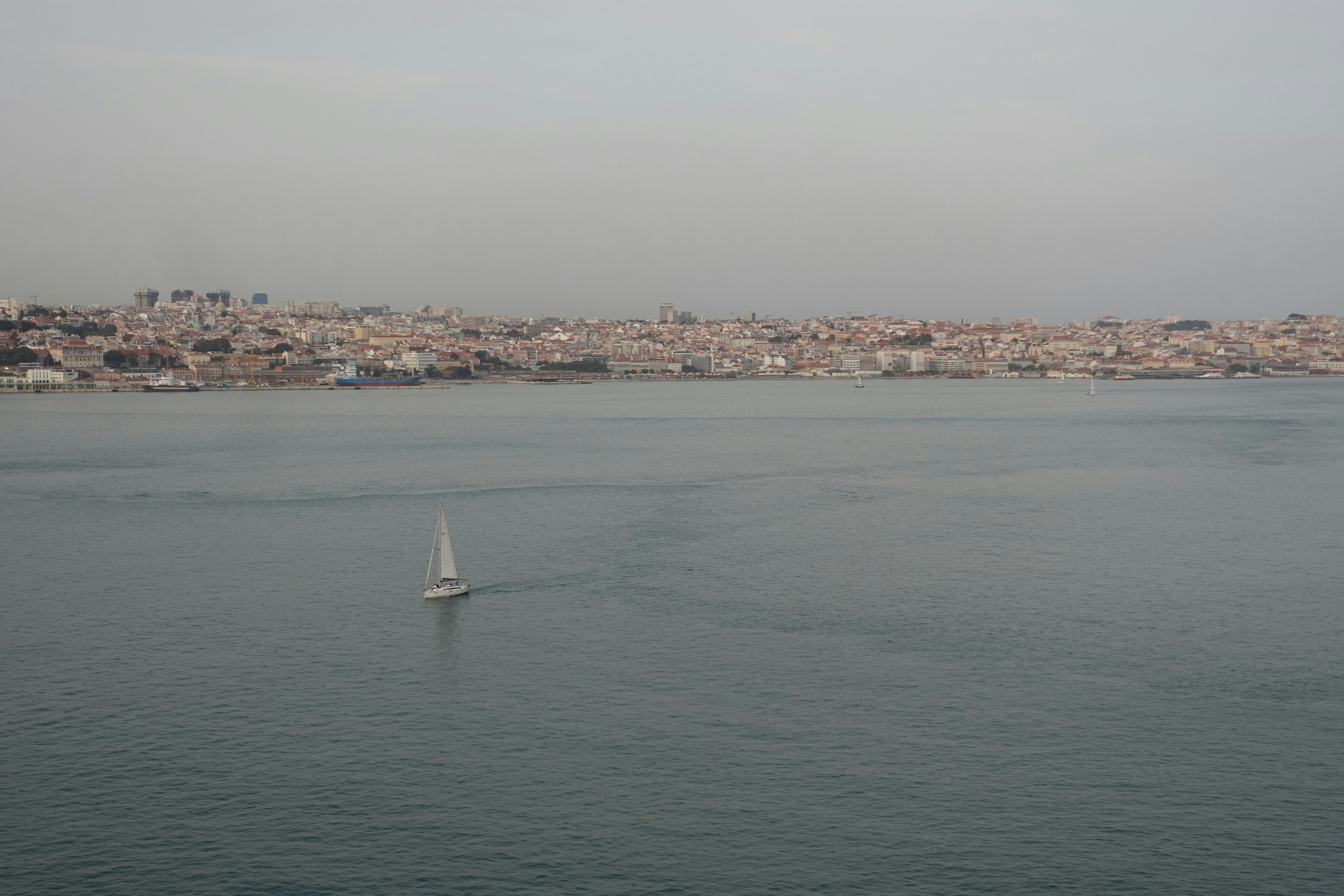 Sailboat on the water with city in background