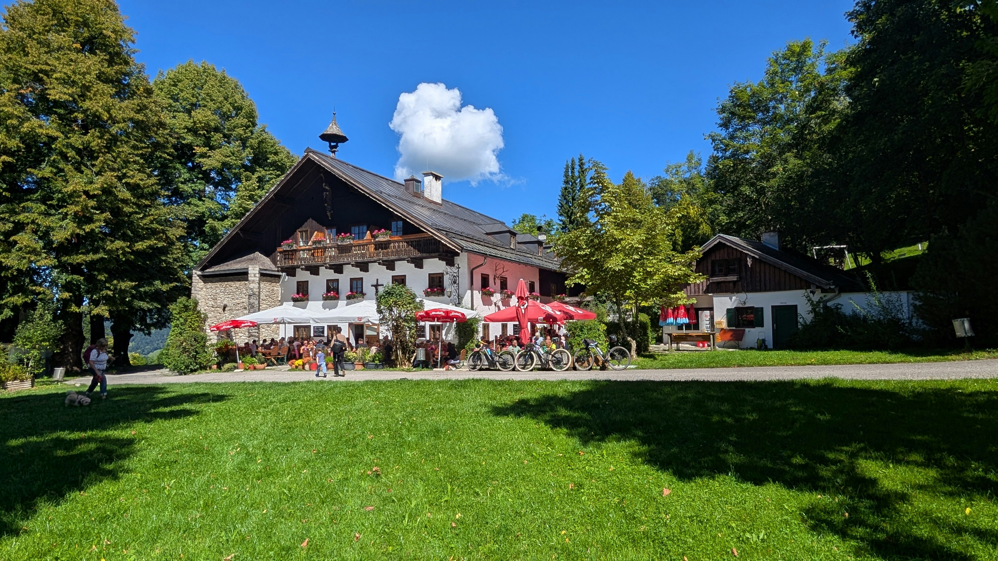 Traditional austrian building with outdoor seating and red umbrellas