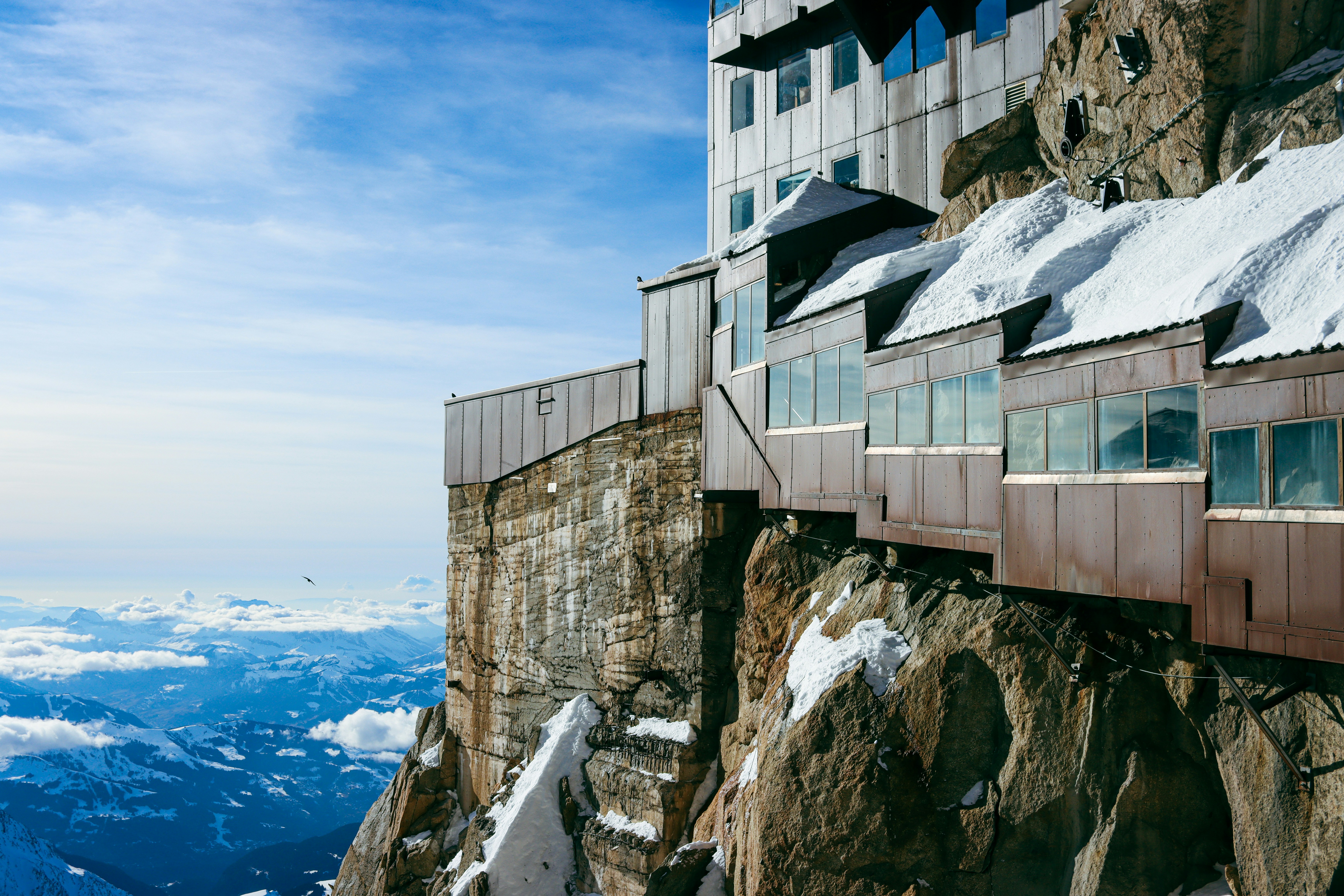 Building perched on a rocky mountain cliff under blue sky
