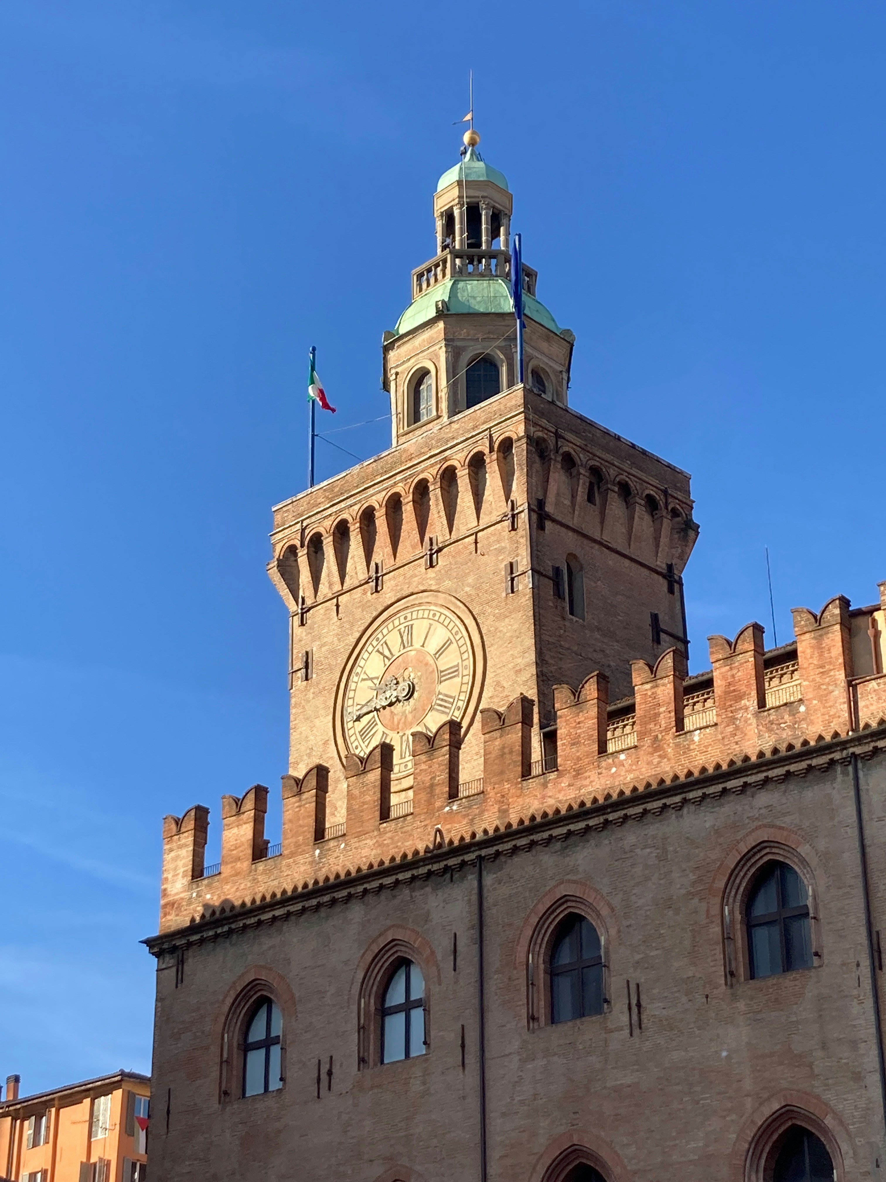 Clock tower with crenellations against a blue sky