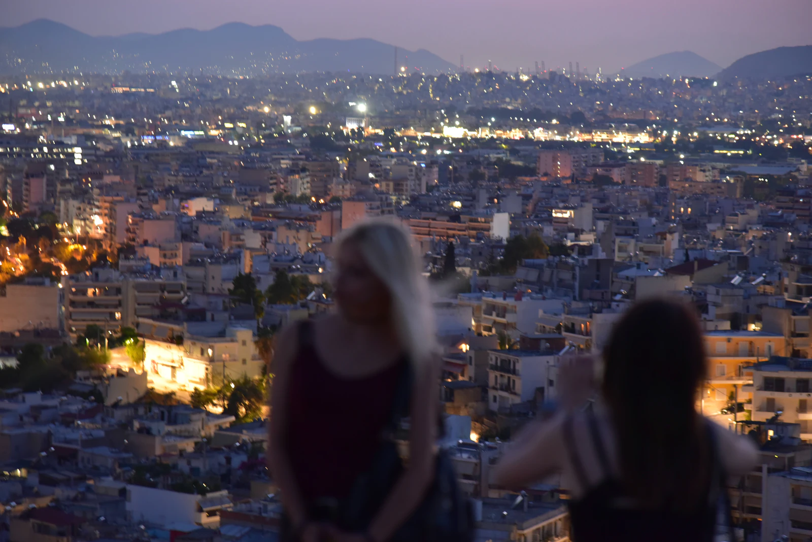 Two residents overlooking city lights at dusk