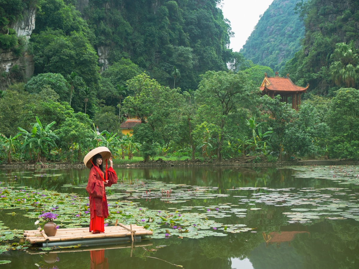 Woman in traditional dress on raft in a serene lake
