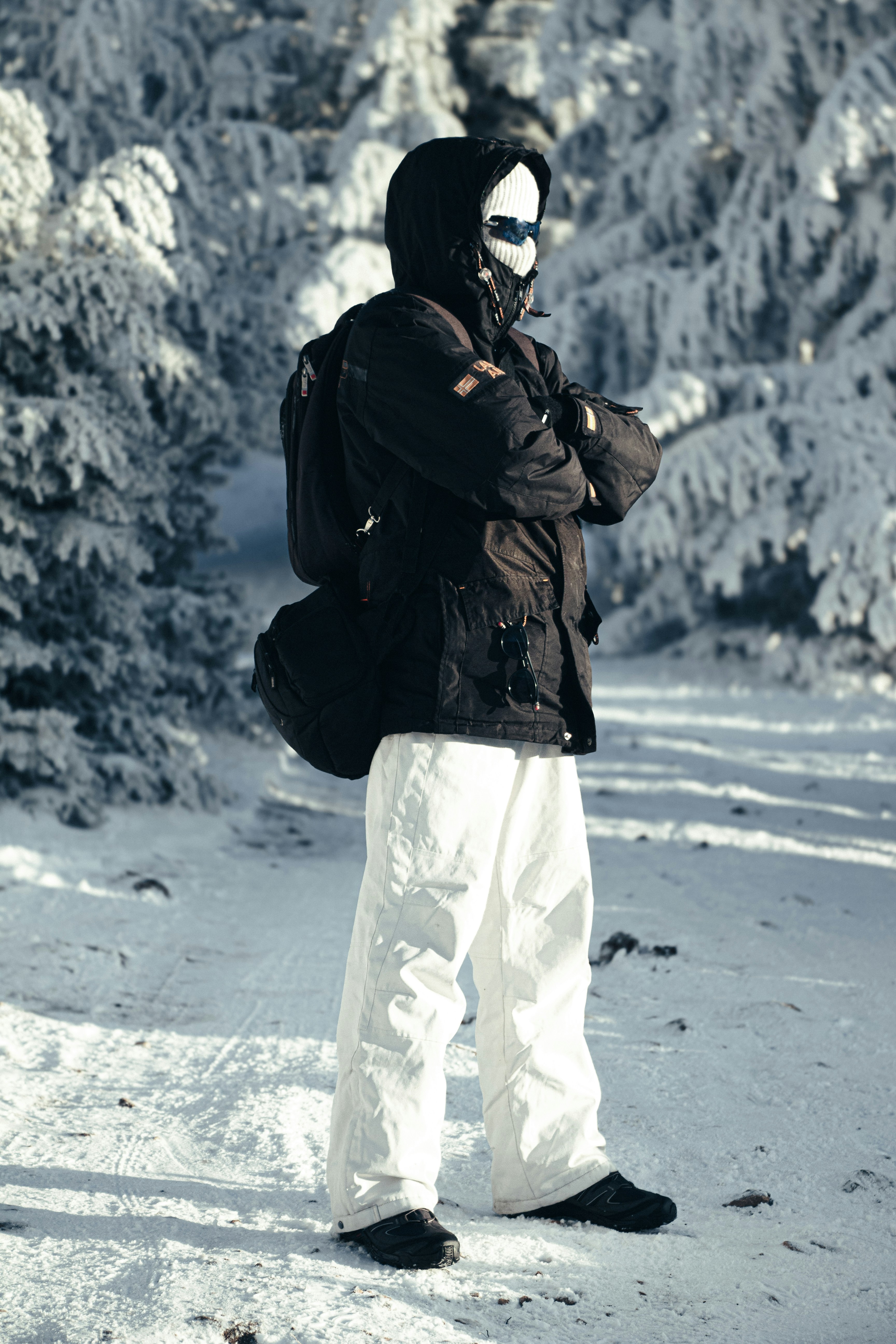 Person in winter gear standing in snowy forest