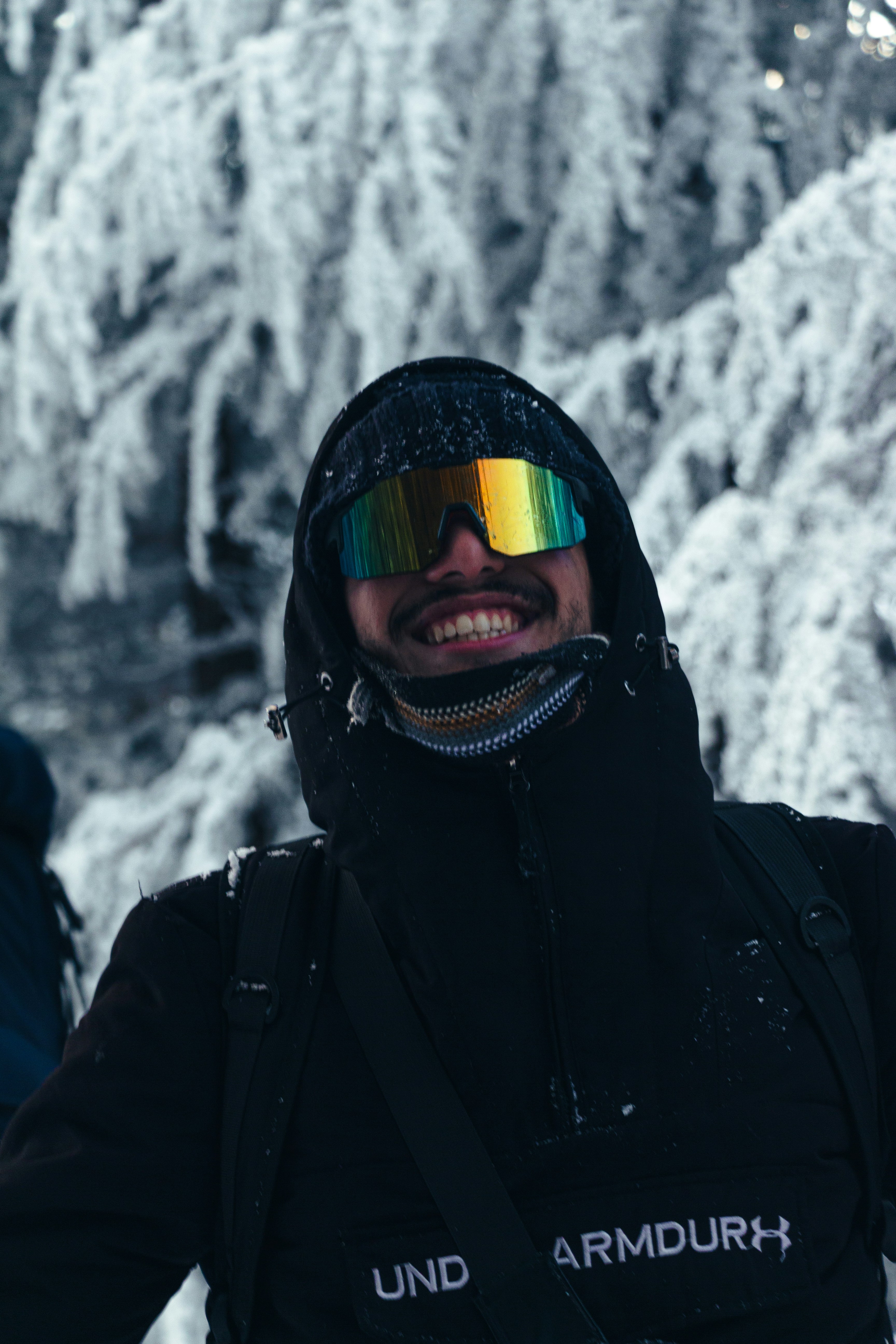 Man wearing ski goggles in snowy forest