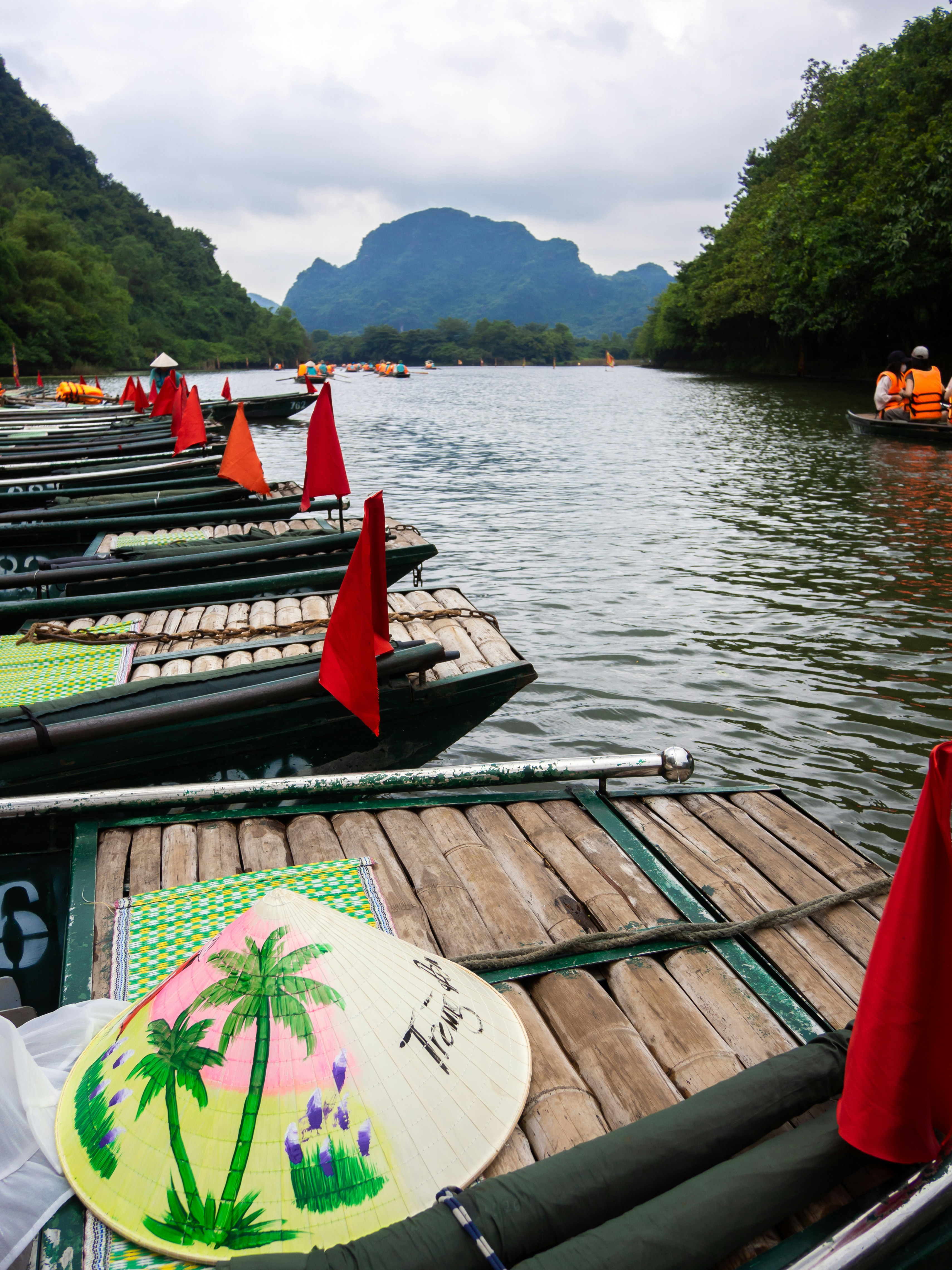 Boats lined up on a river with mountains in background