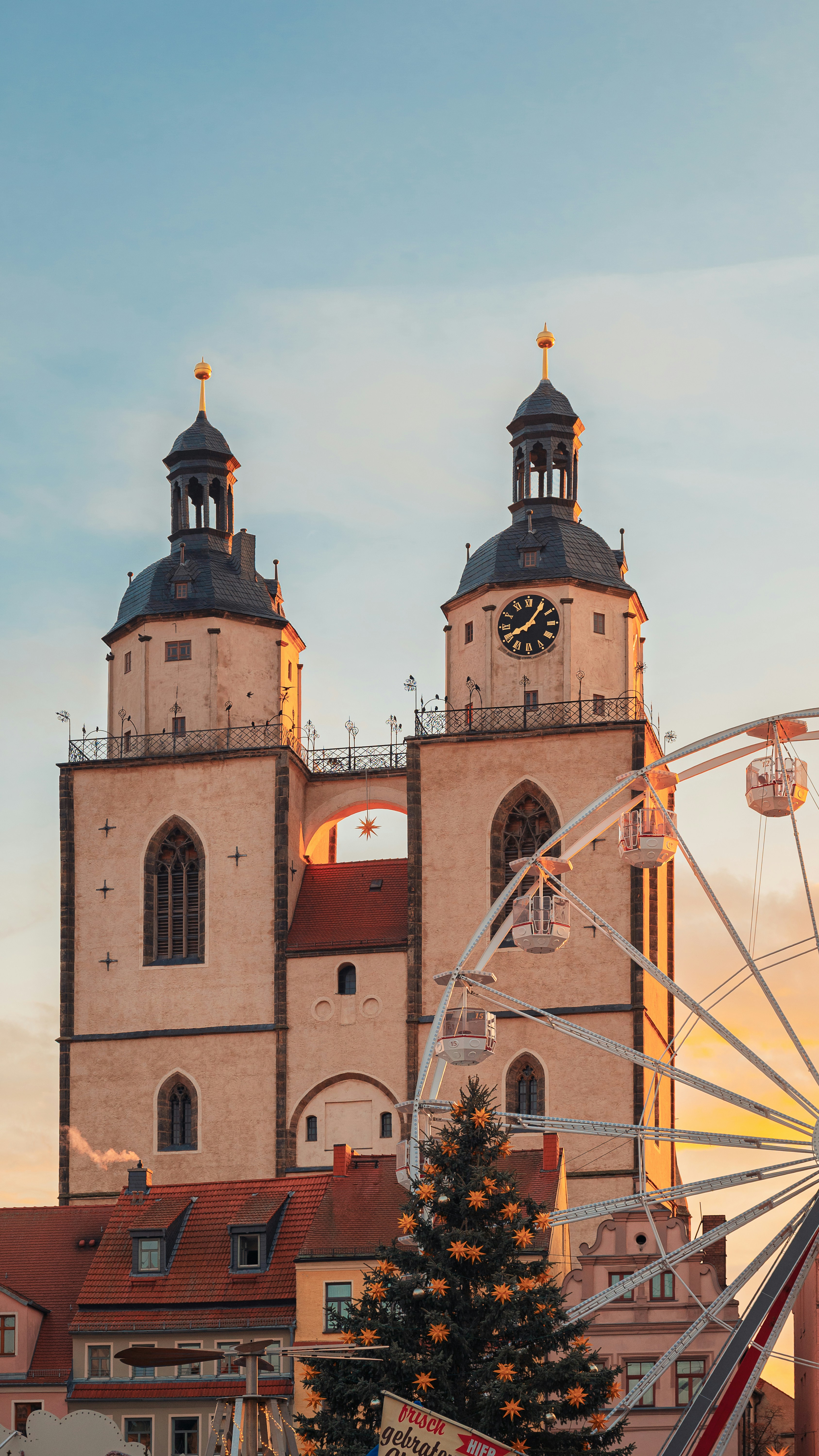 Ferris wheel and church towers at sunset