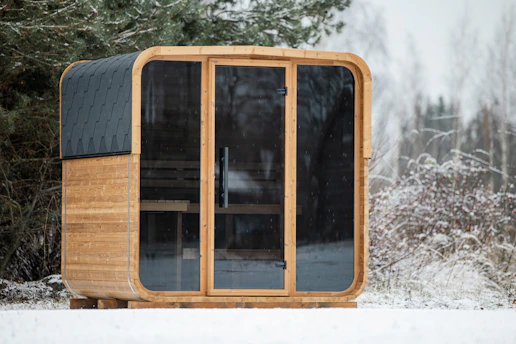 Modern wooden sauna cabin in snowy landscape