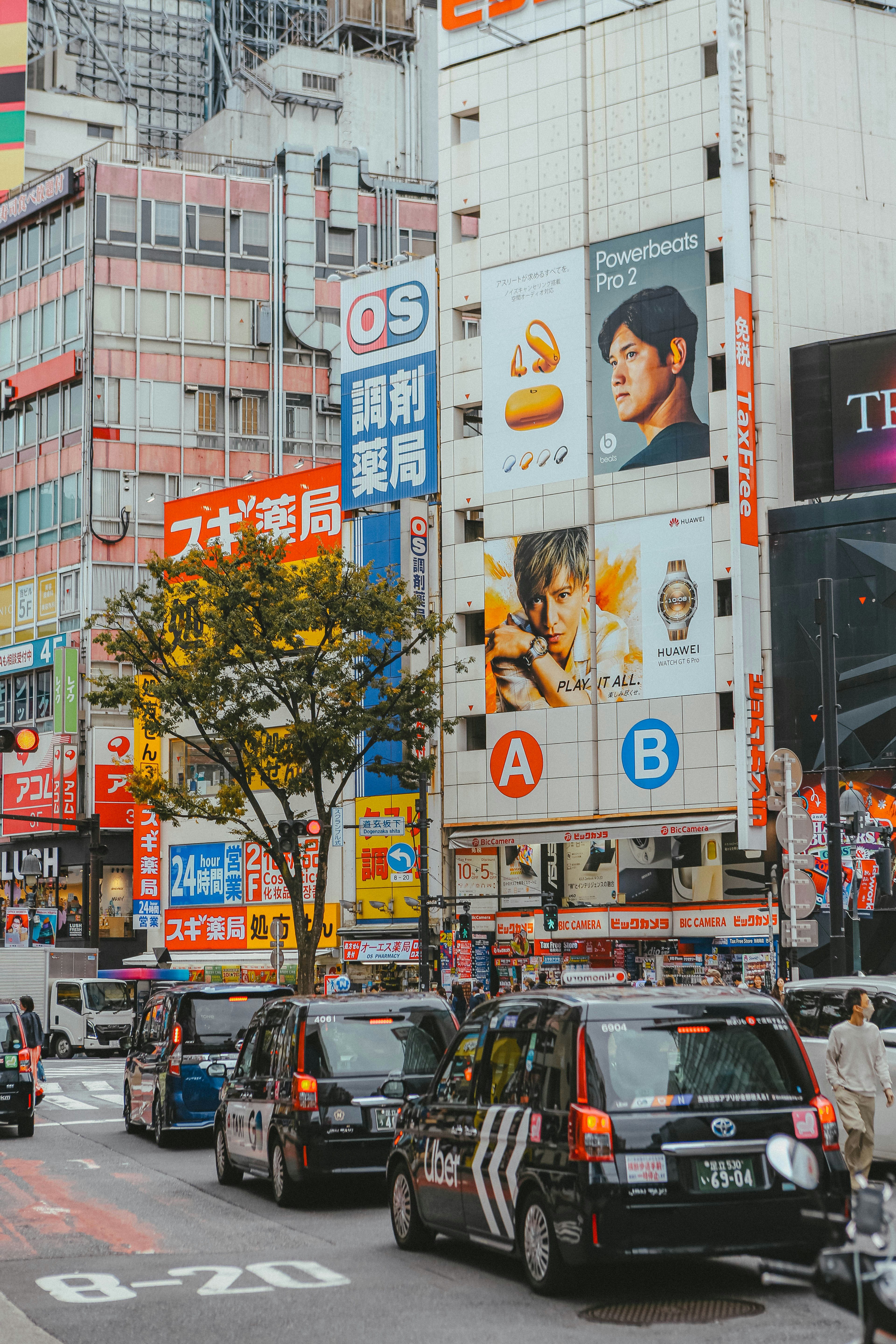 Busy street with cars and tall buildings in tokyo.
