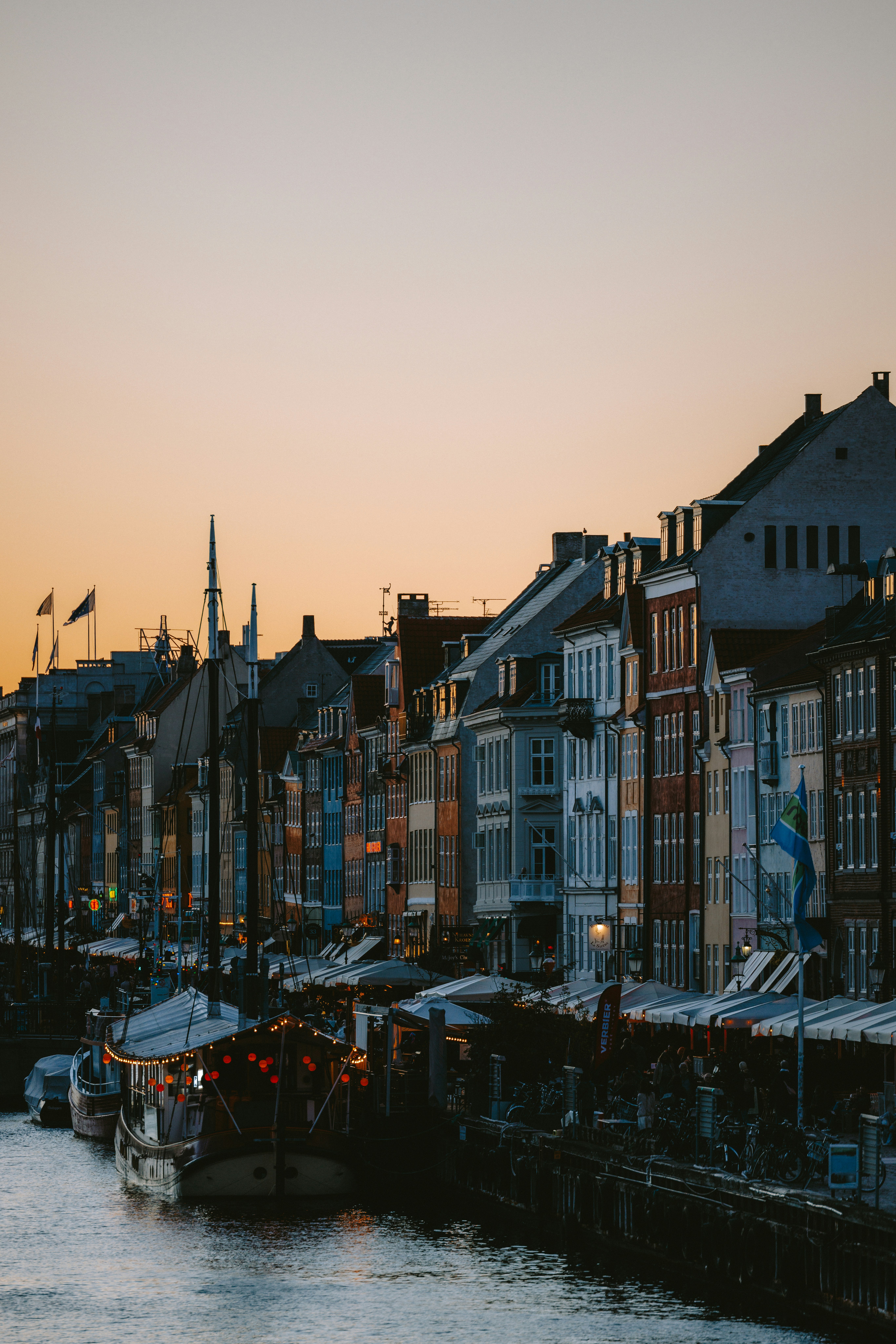 Colorful buildings line a canal at dusk