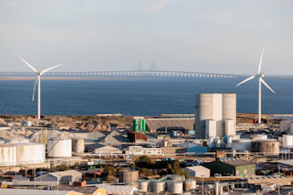 Wind turbines and industrial buildings by the sea