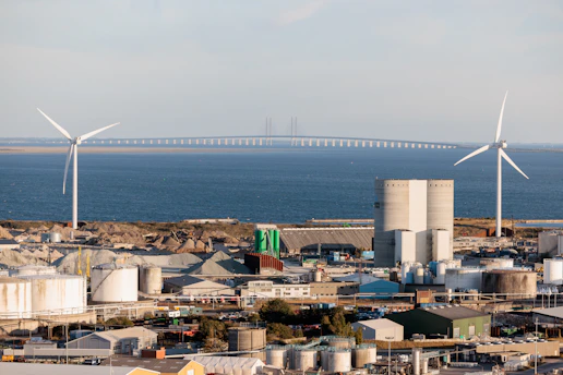 Wind turbines and industrial buildings by the sea