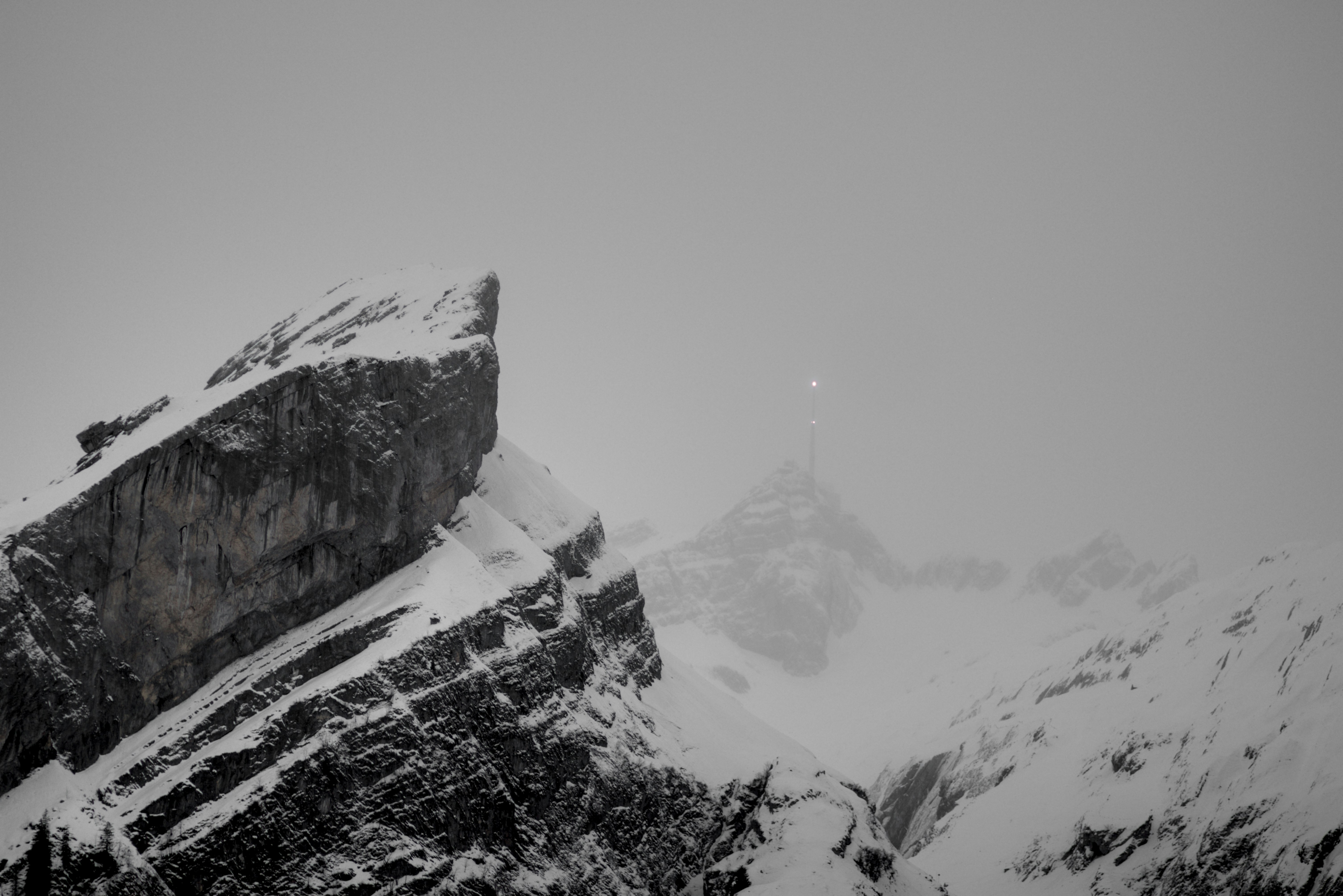 Snowy mountain peaks under a hazy sky