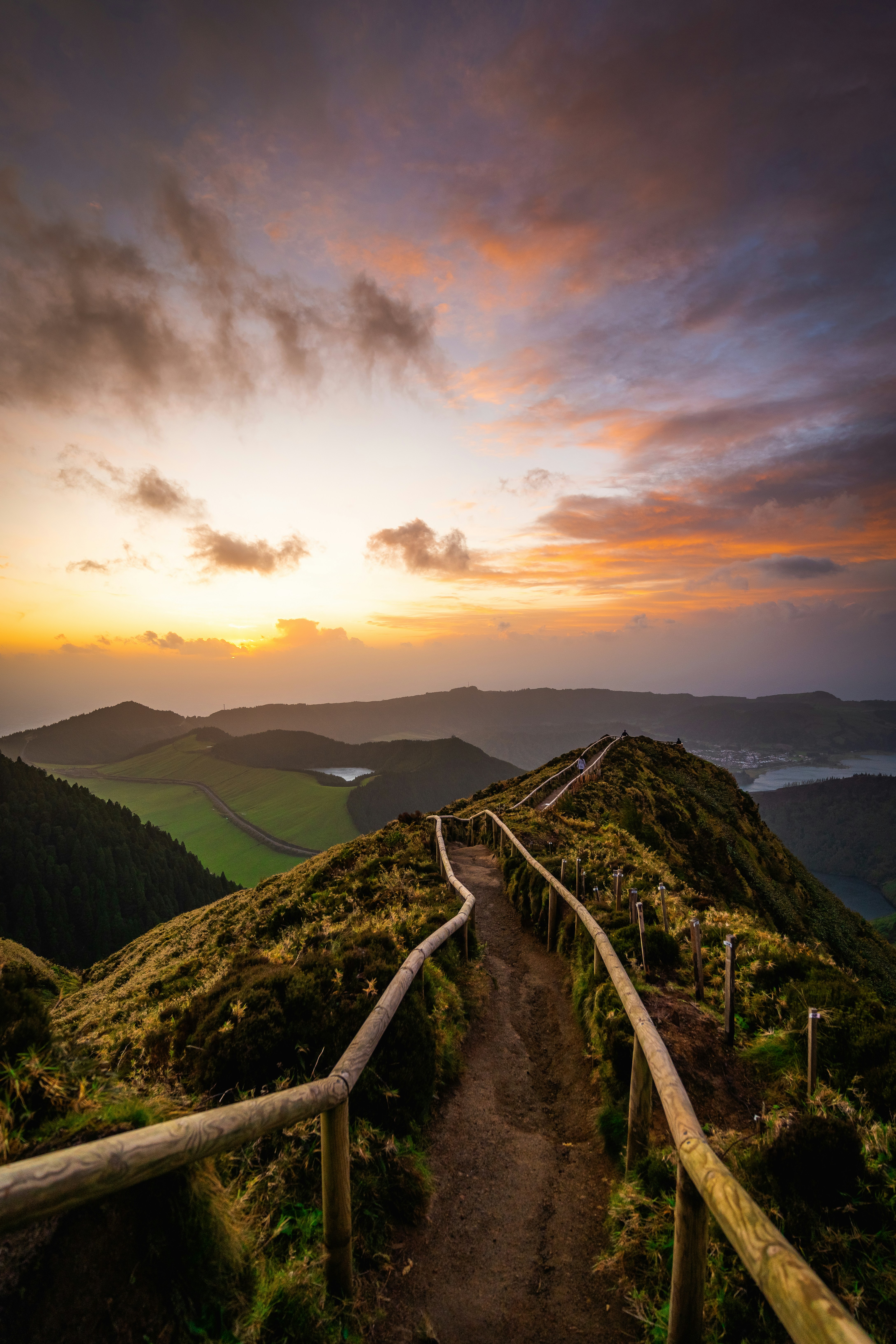 Mountain path with wooden fence at sunset
