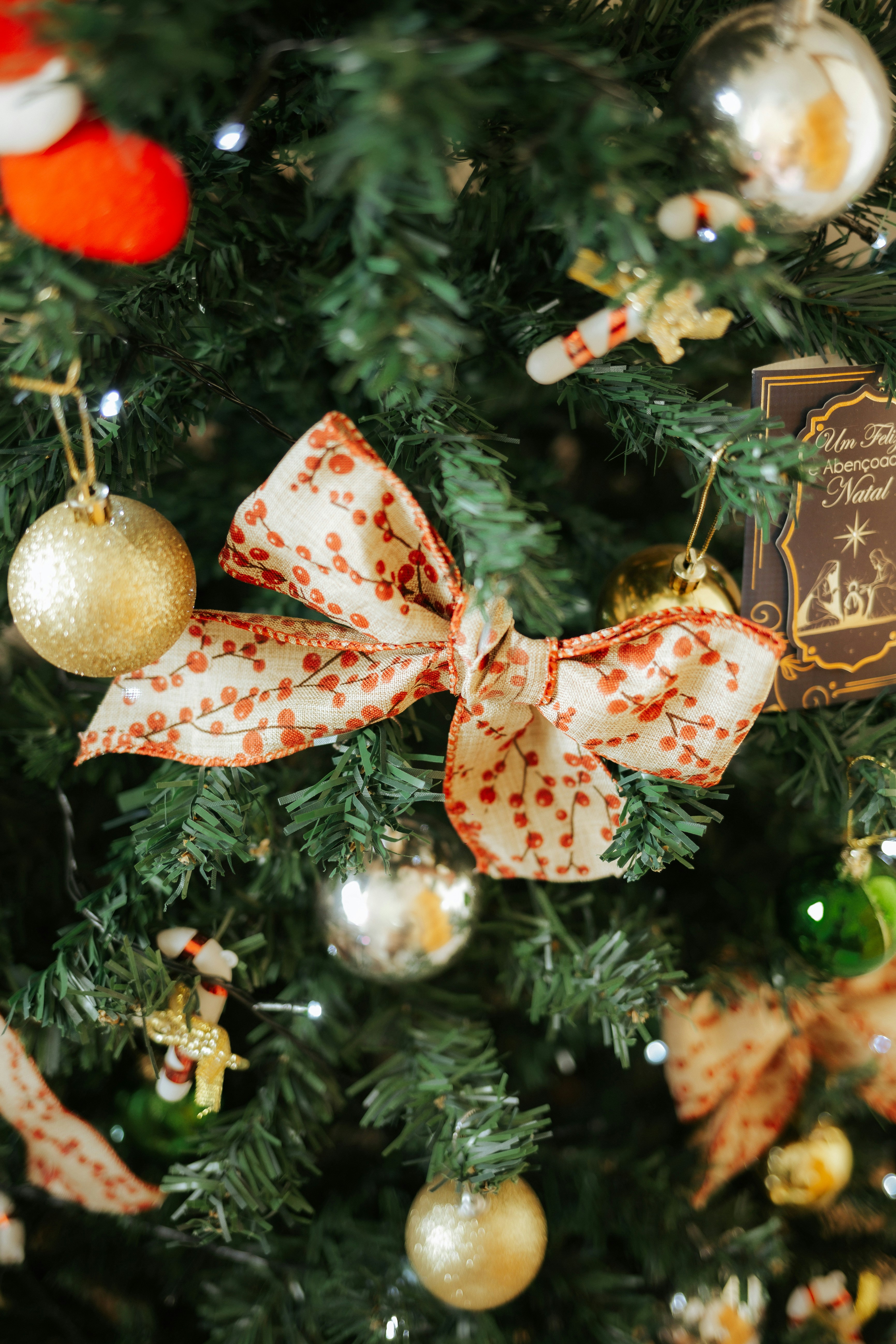 Uma árvore de Natal festiva com enfeites e laços.