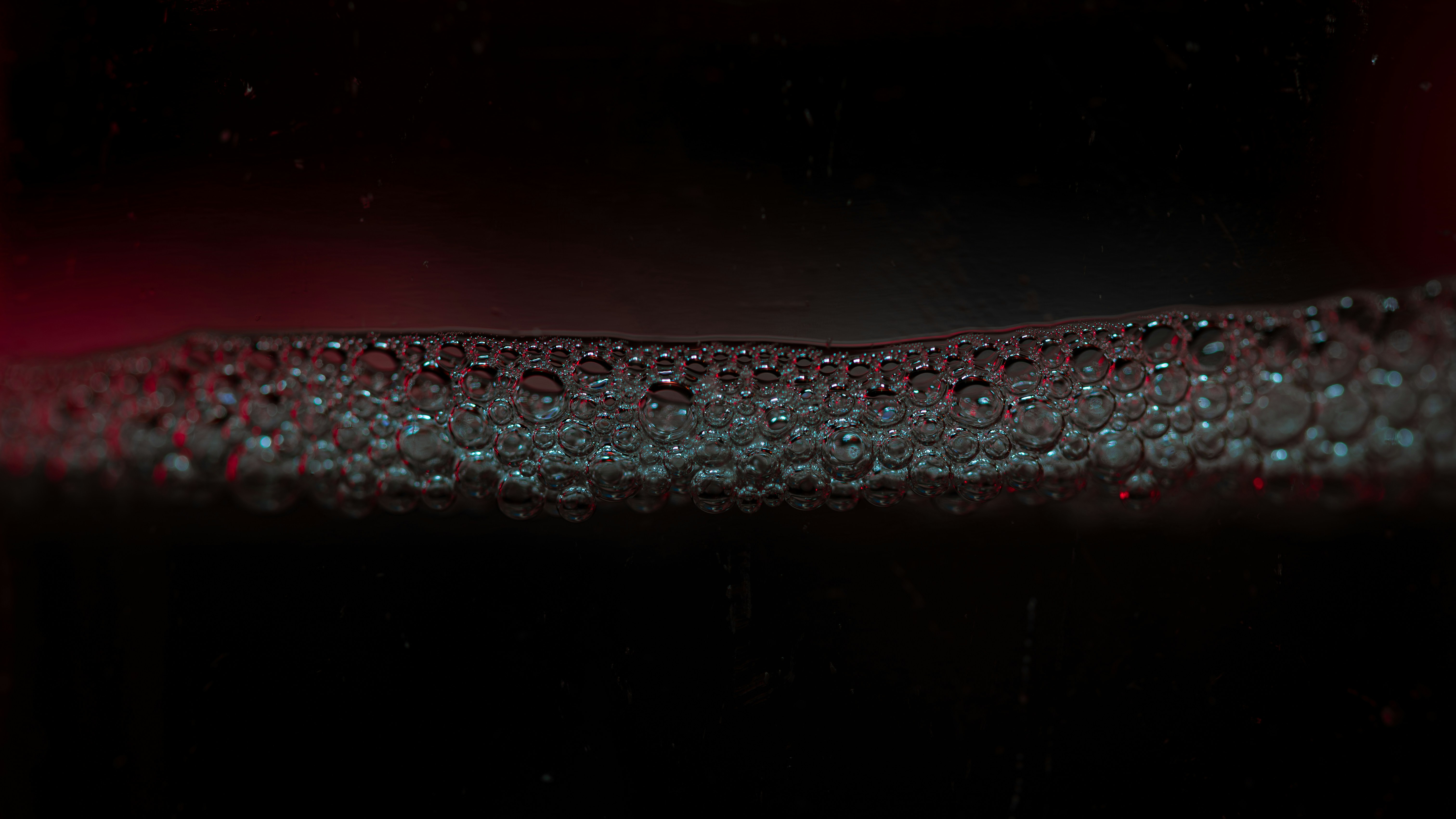 Close-up of small bubbles on a dark surface.