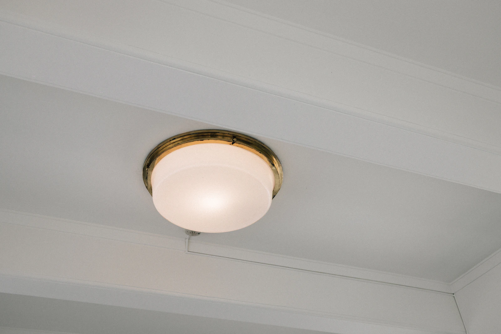 White ceiling light fixture with a brass trim